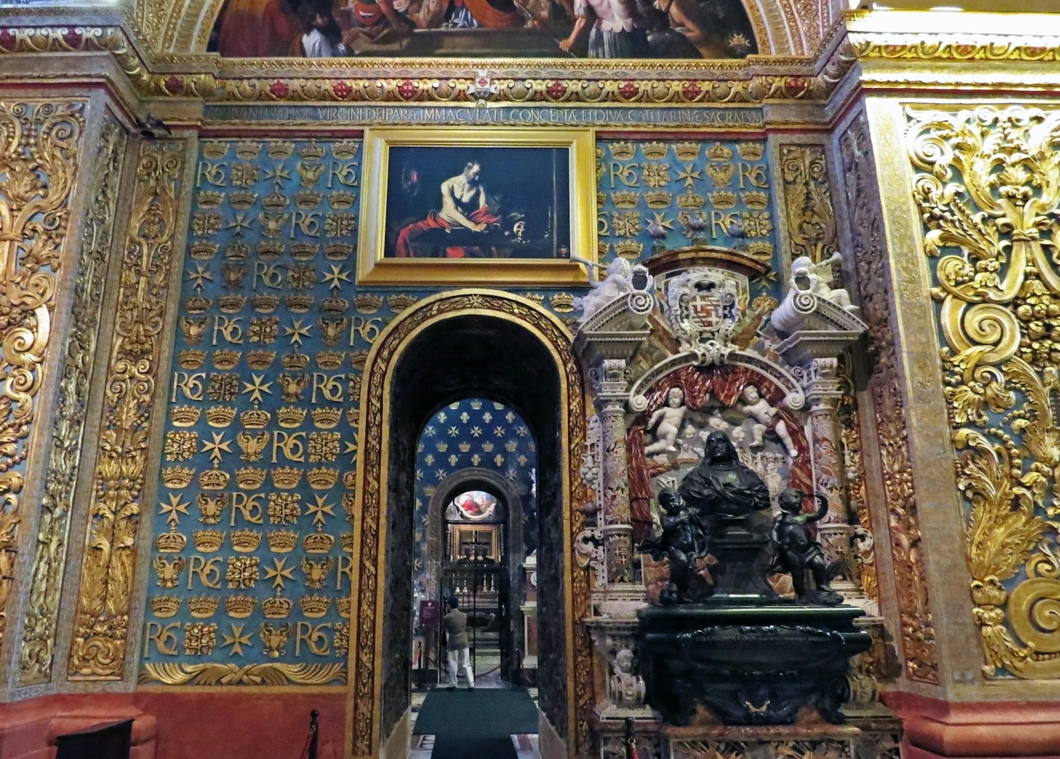 Interior de una iglesia con decoraciones doradas ornamentadas que presentan azulejos azules y pinturas en las paredes
