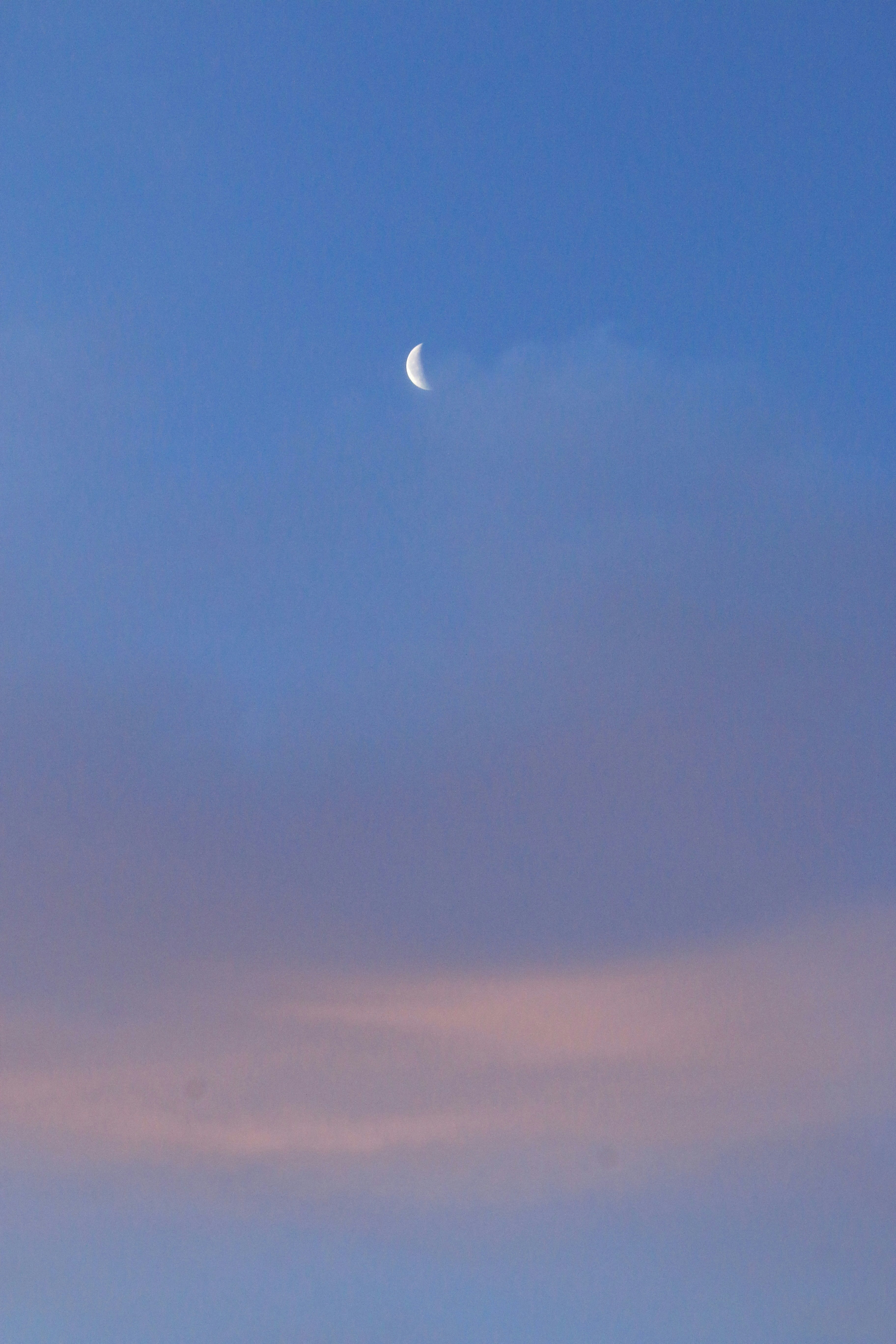 Moon over a blue sky with sunset gradient