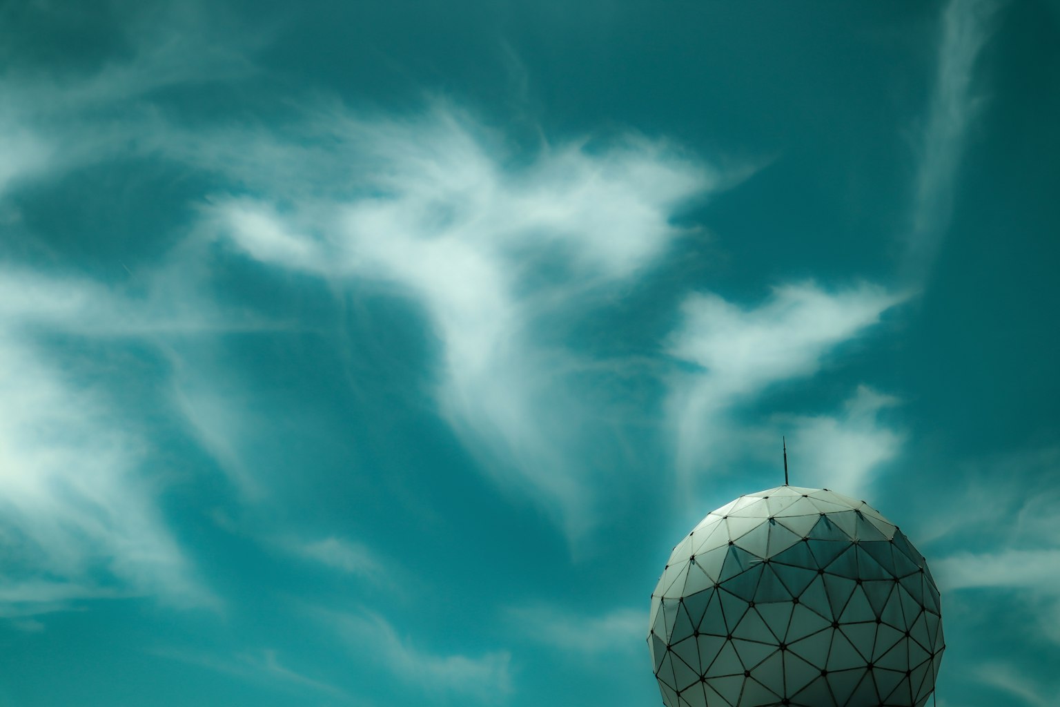 Large dome-shaped structure against a blue sky with white clouds