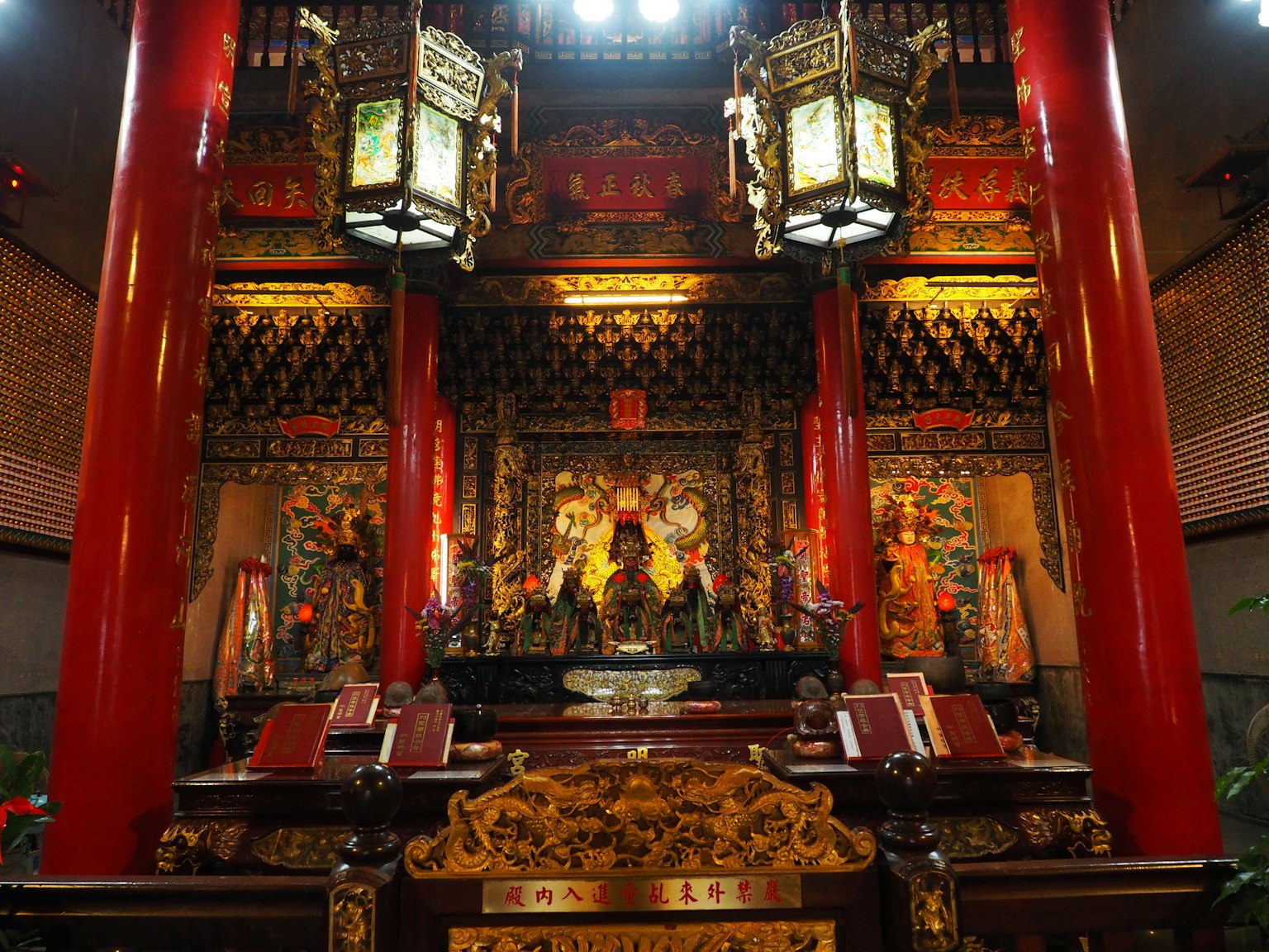 Interior of a temple with red pillars and intricate decorations