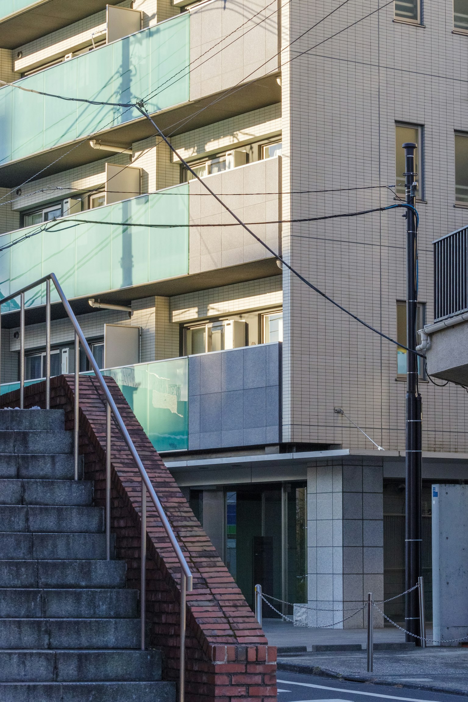 Staircase leading to a modern building with green balconies
