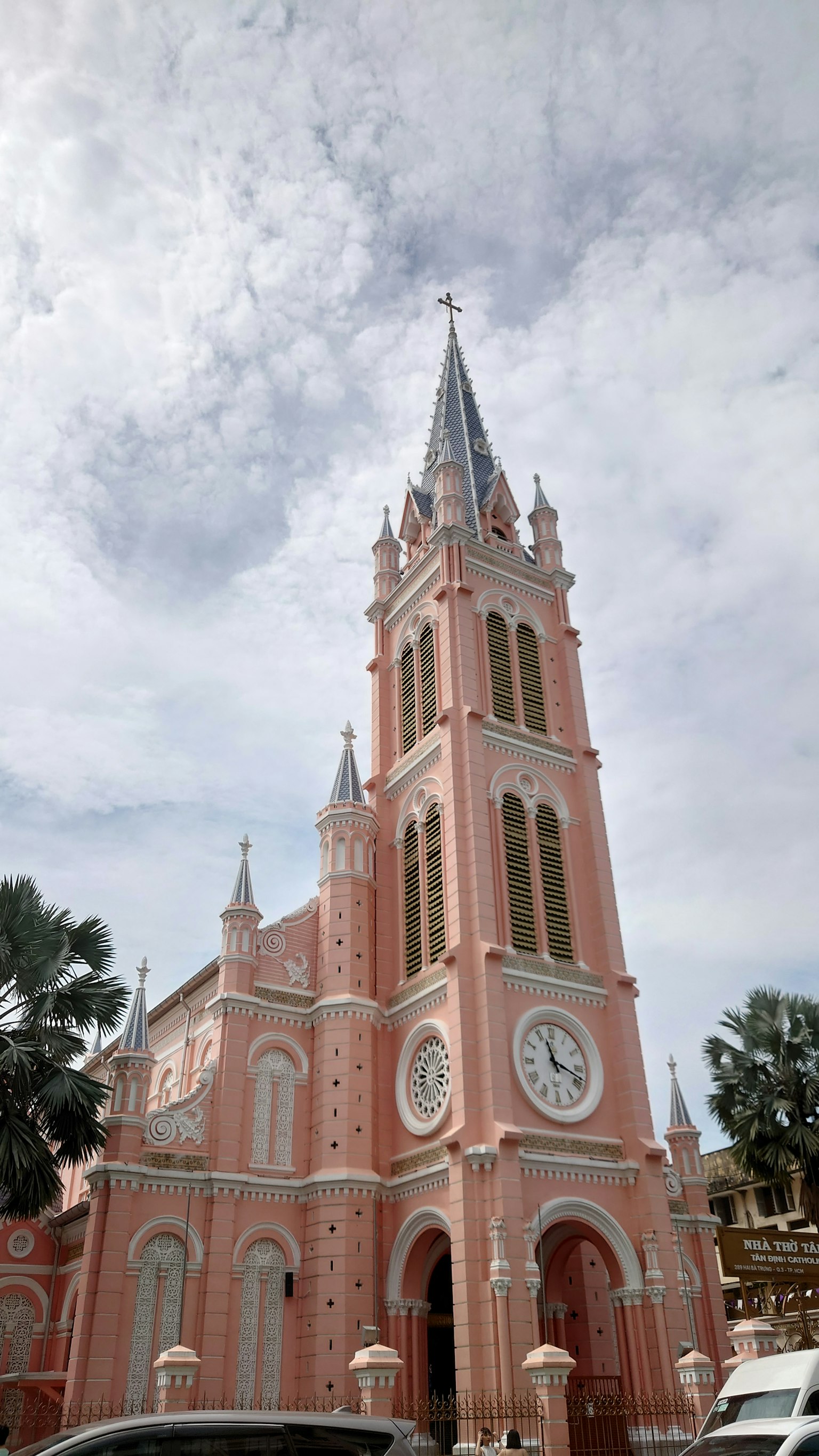 A pink church featuring a tall clock tower