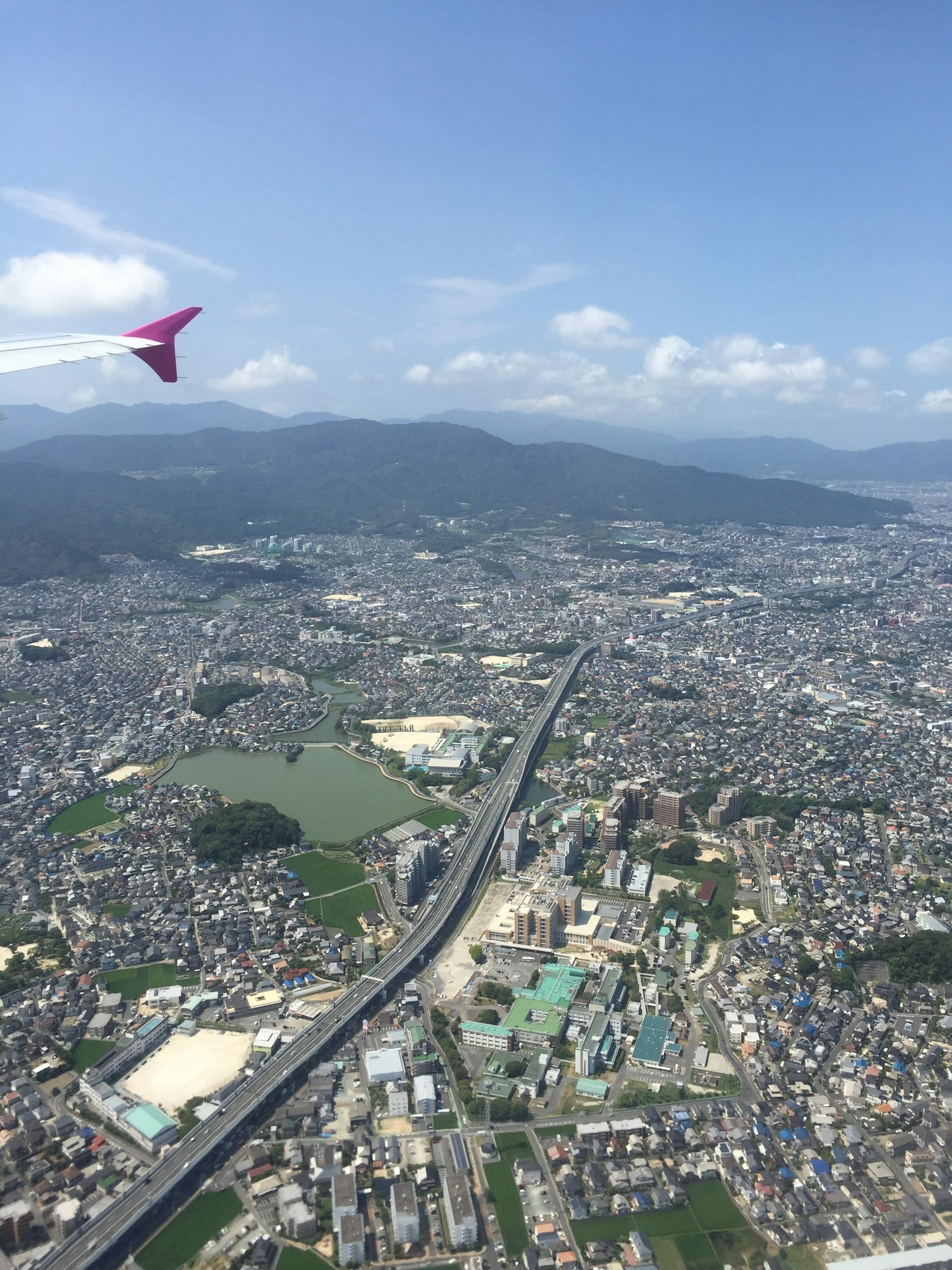 Vista aerea di un paesaggio urbano con un'ala di aereo nell'angolo