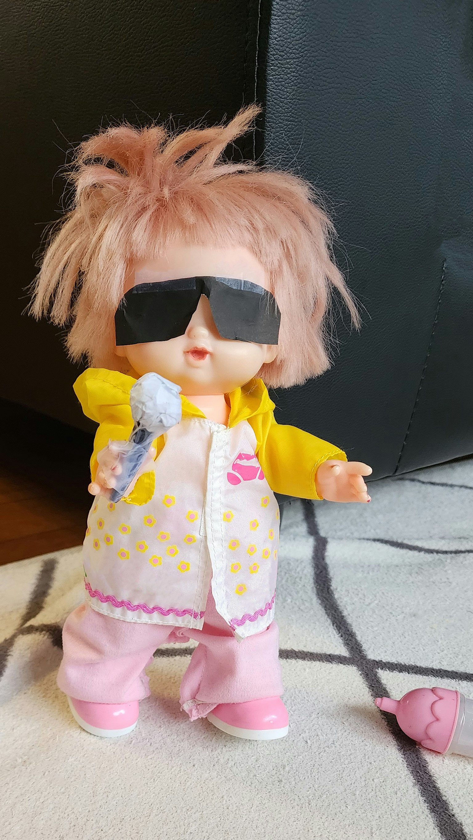 Poupée mignonne portant des lunettes de soleil tenant un microphone