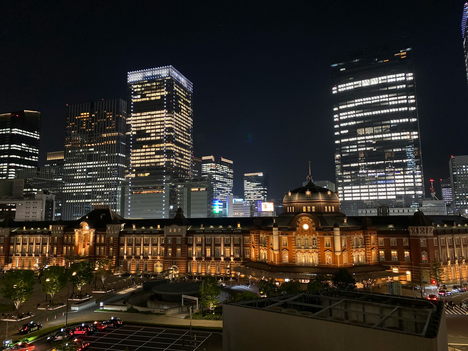 Vista nocturna de la estación de Tokio con rascacielos modernos