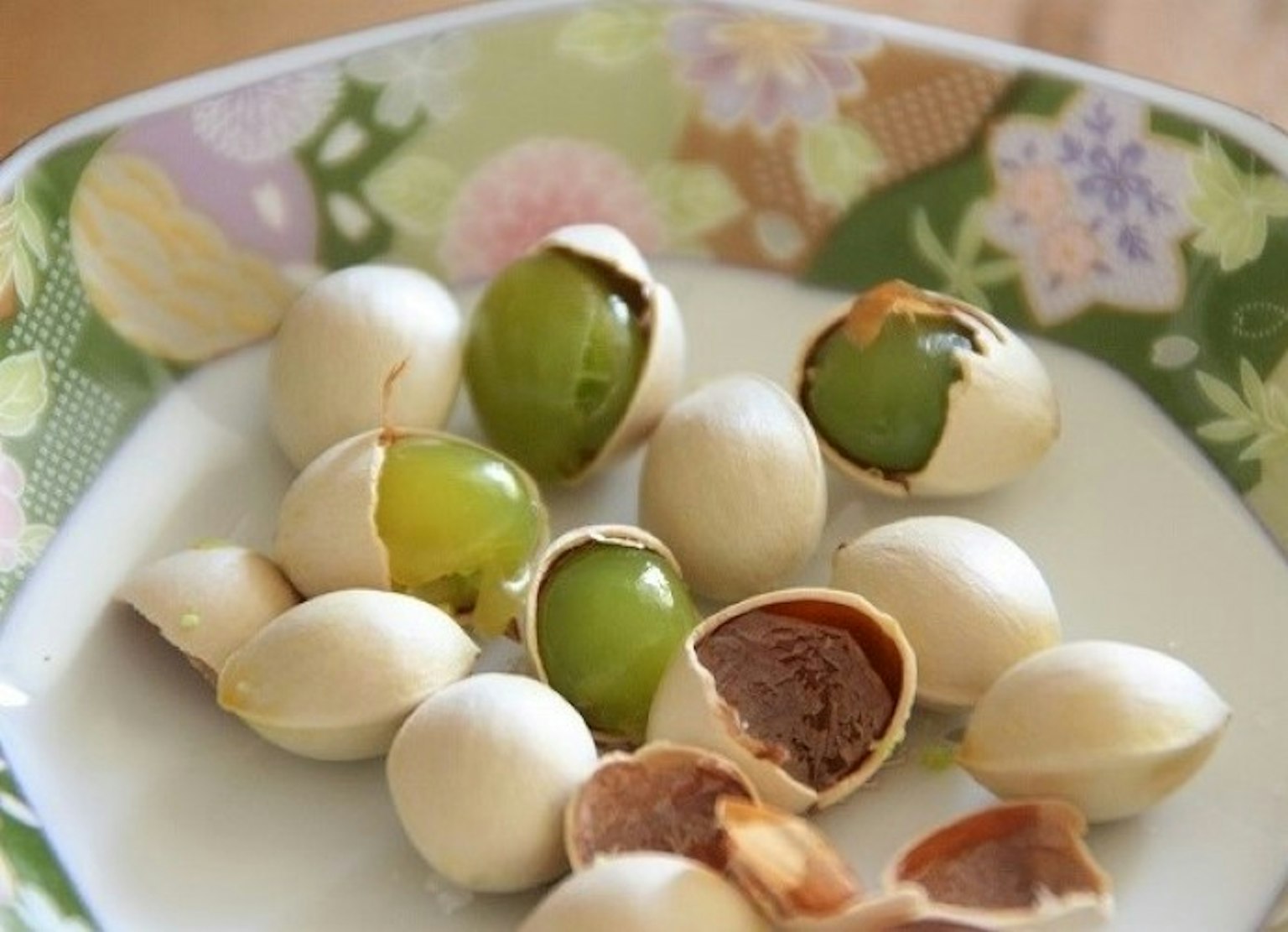 Teller mit grünen Früchten und angeordneten Nussschalen