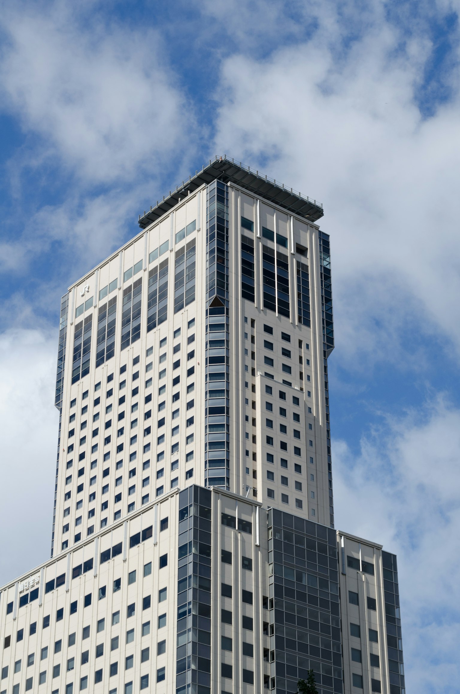 Nahaufnahme eines Wolkenkratzers vor blauem Himmel