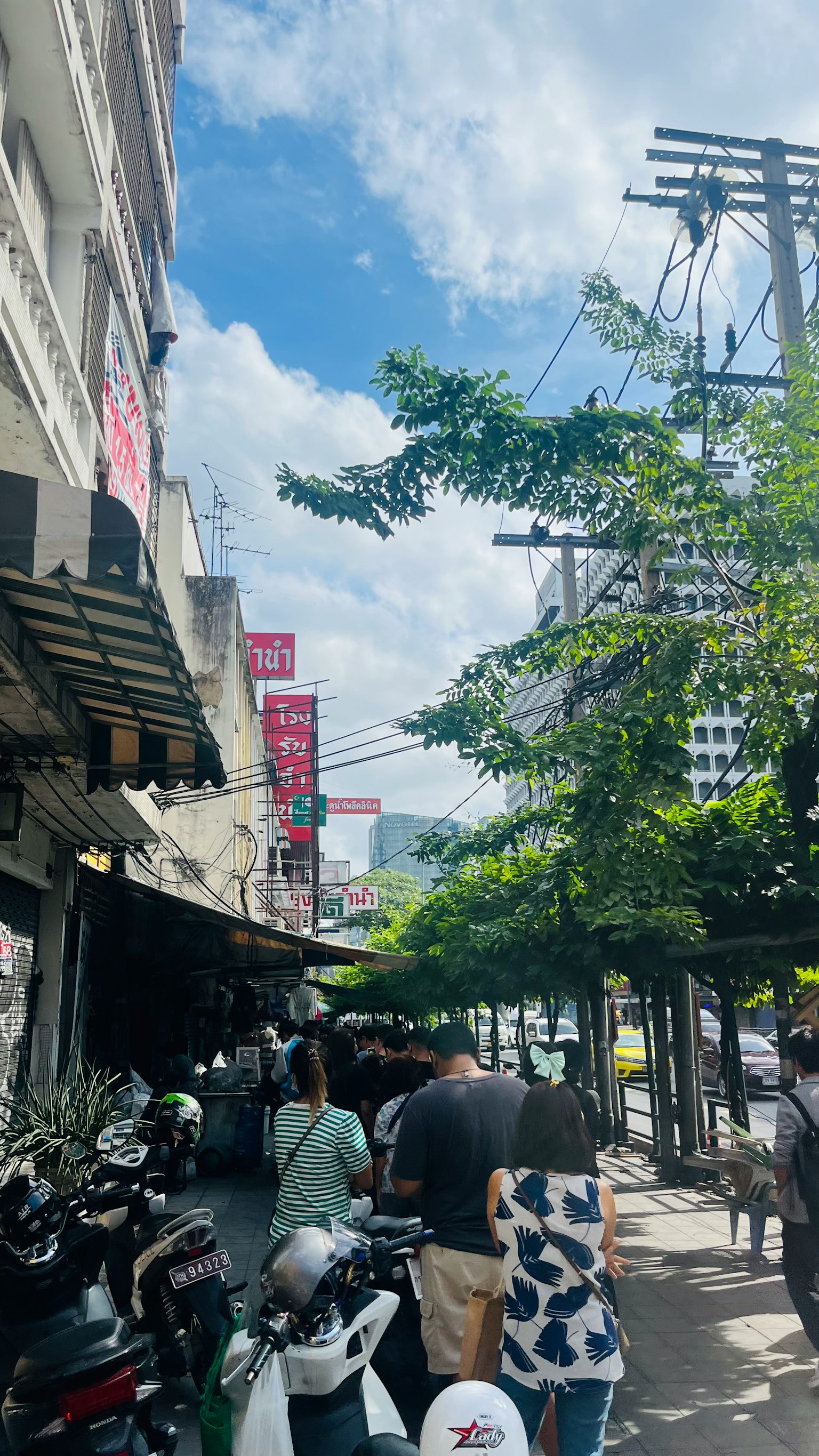 Cảnh đường phố ngoài trời với mọi người xếp hàng tại nhà hàng dưới bầu trời xanh