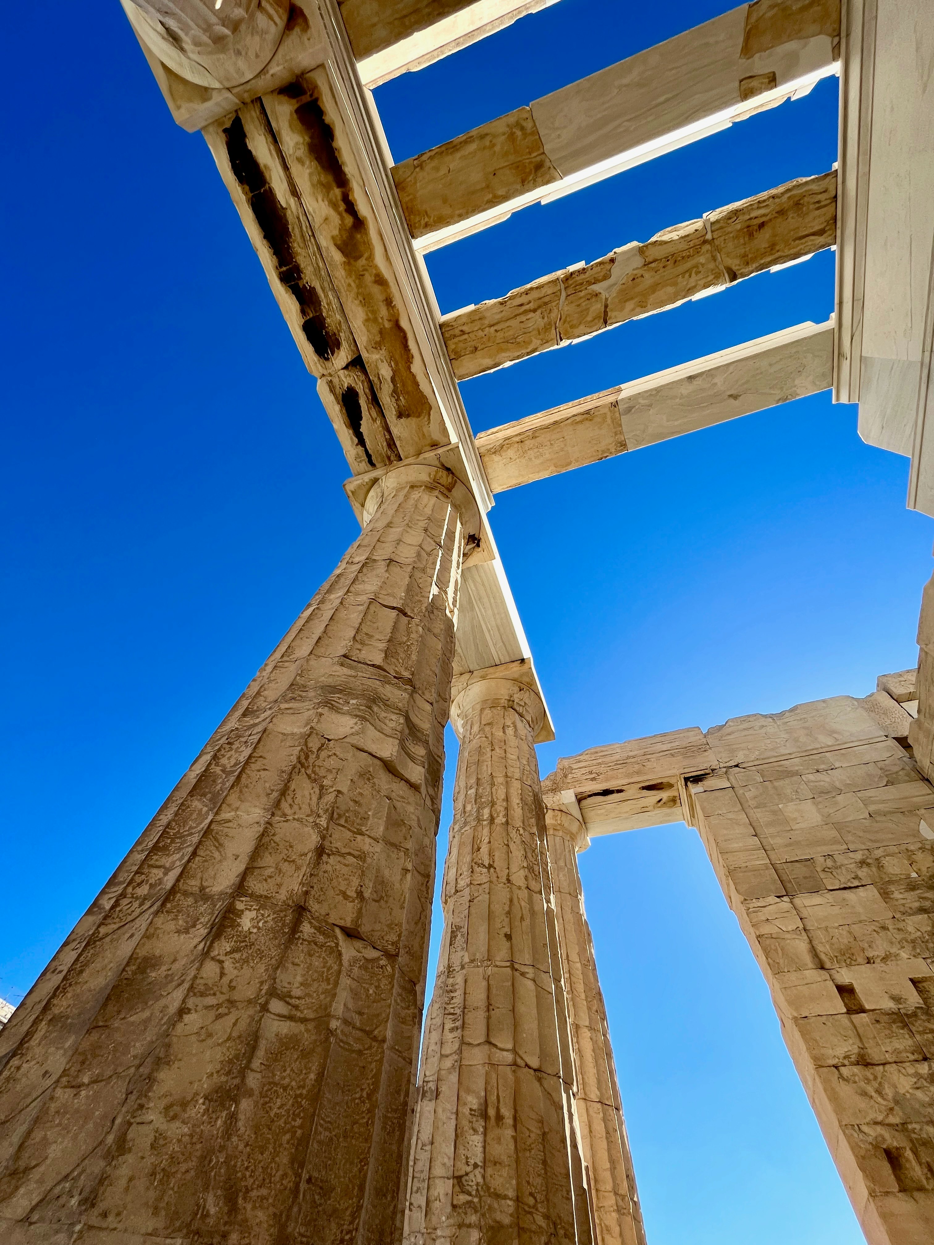 ギリシャ・アテネのアクロポリスの丘にある神殿の石柱と青空に差す光