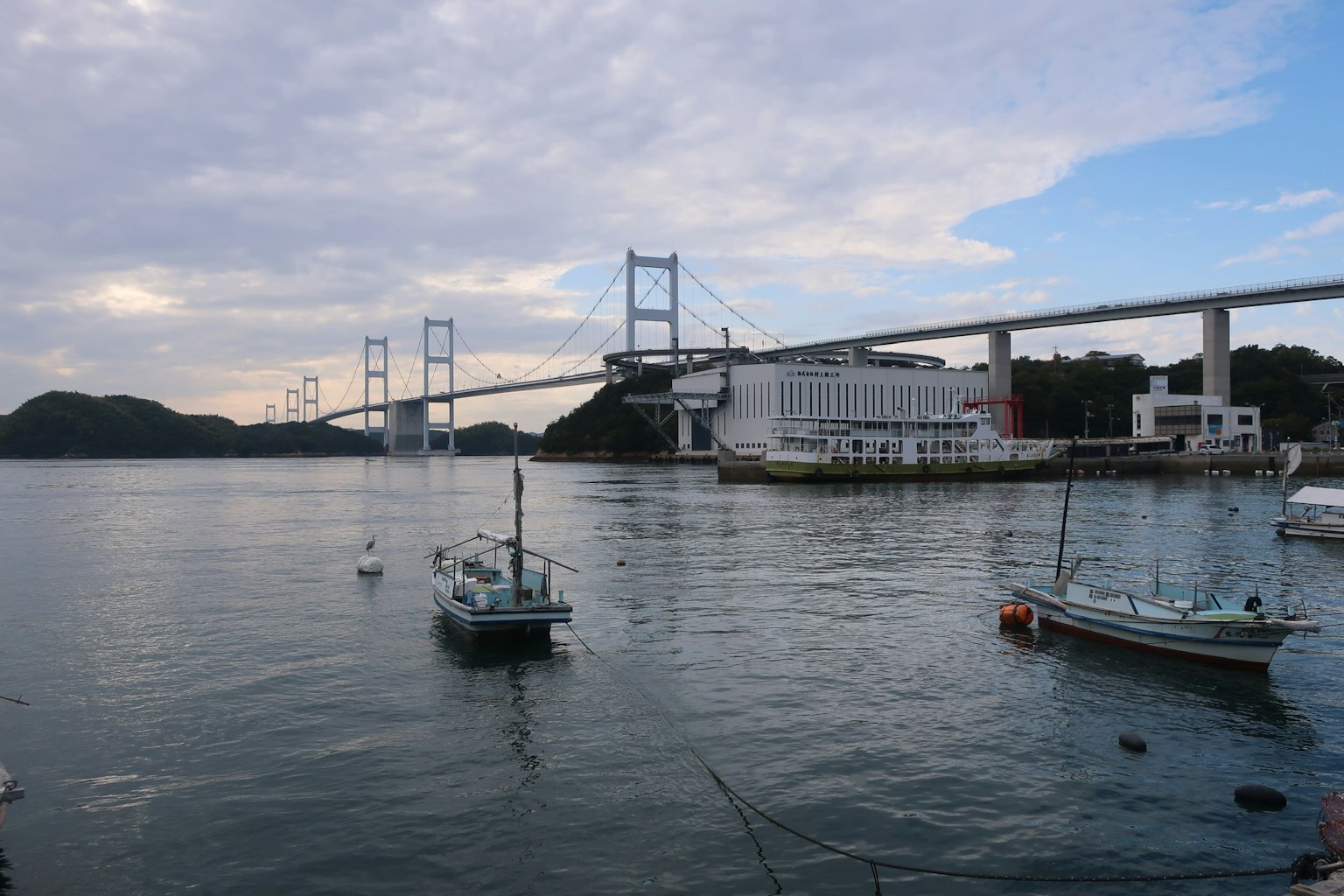 Pemandangan indah perahu kecil di atas air dengan jembatan di latar belakang