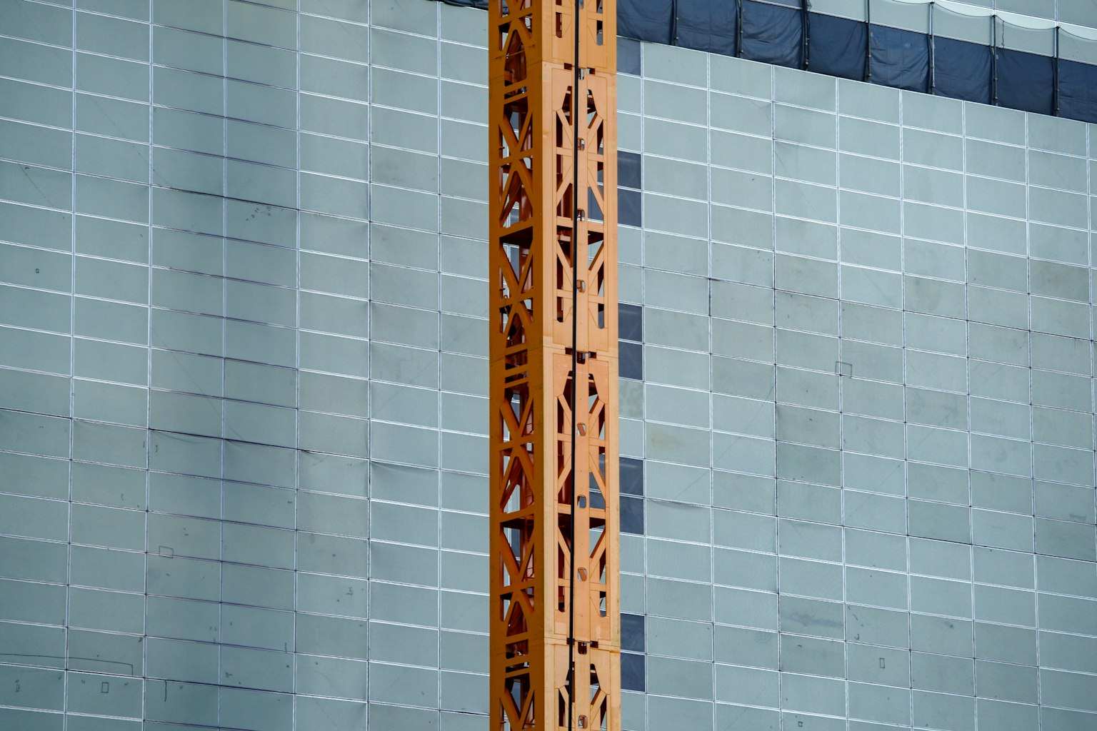 Construction site featuring a wooden crane column and grey wall