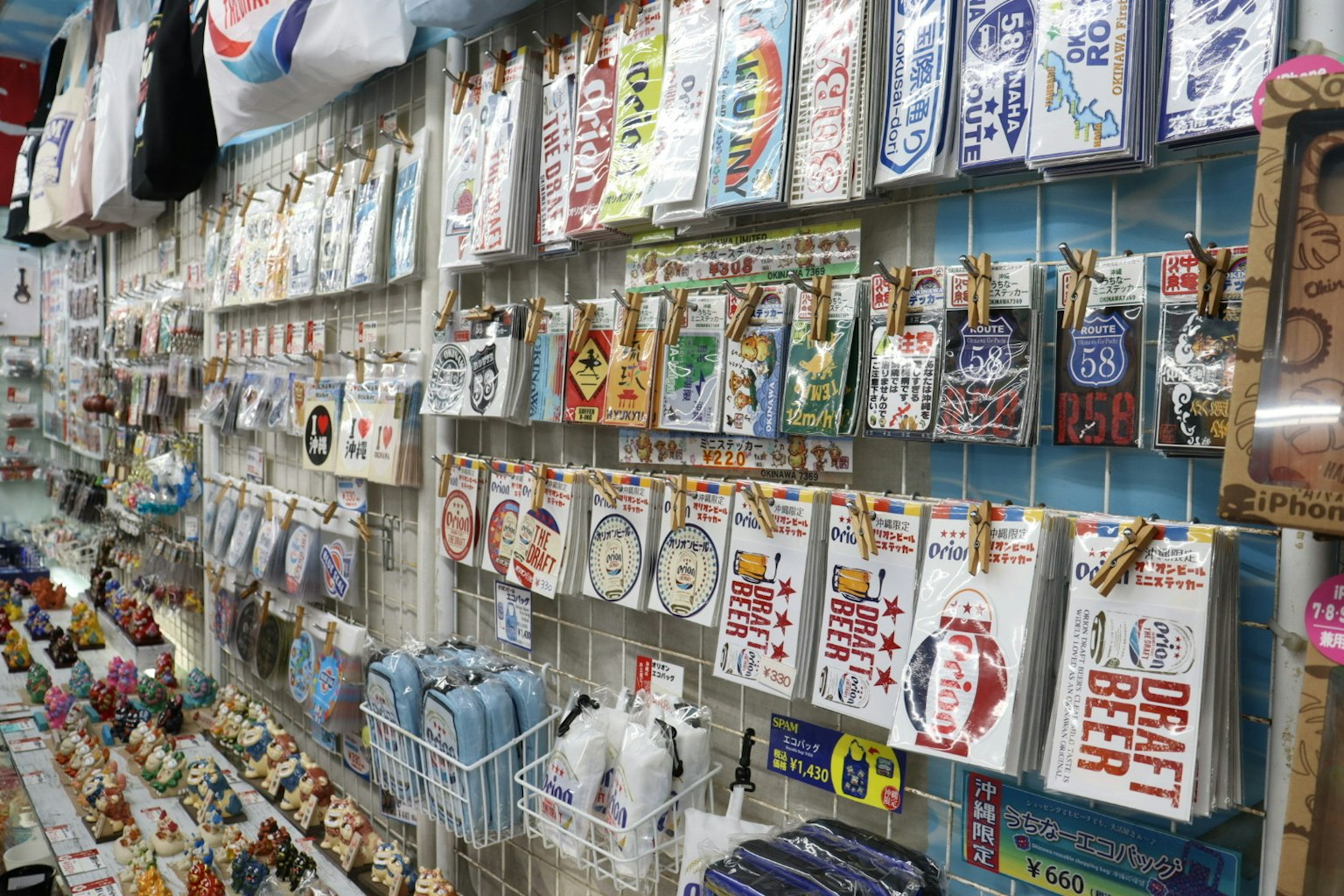 Una exhibición de varias tarjetas y artículos de diseño colgados en una pared de una tienda