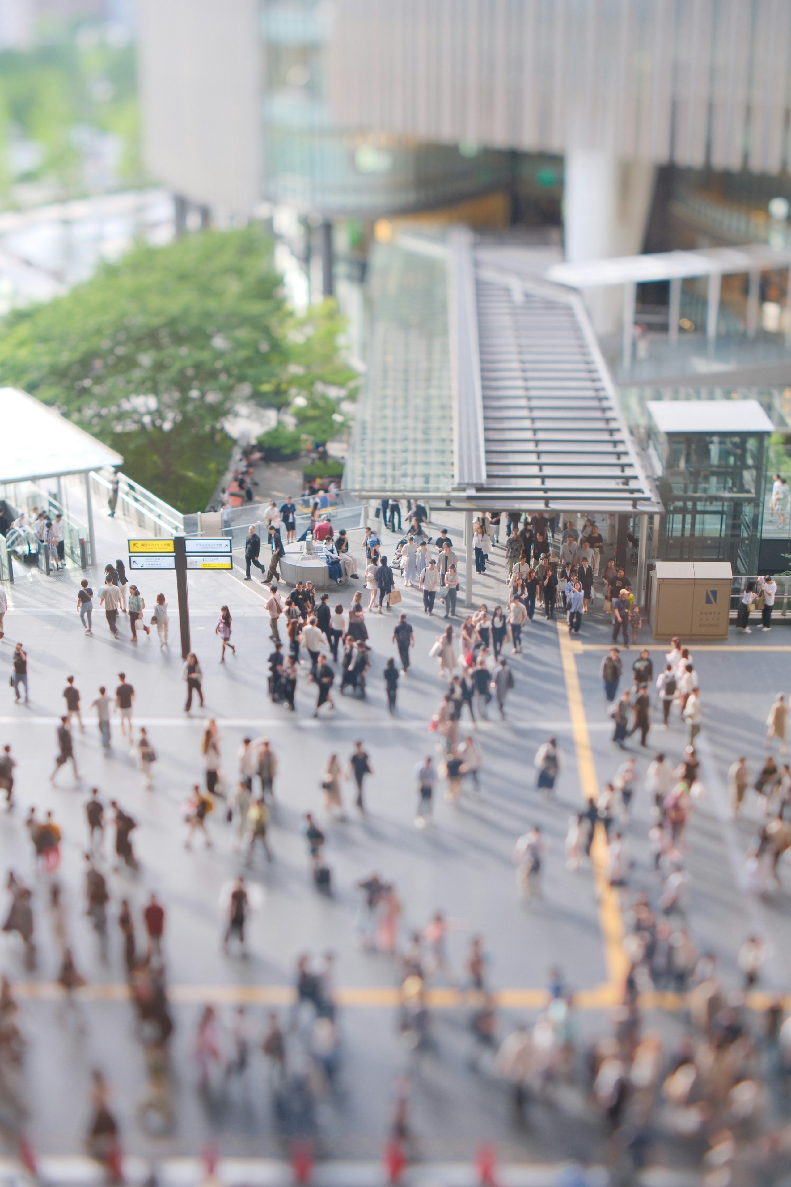 チルトレンズで撮った屋外の人が行き交う広場の風景