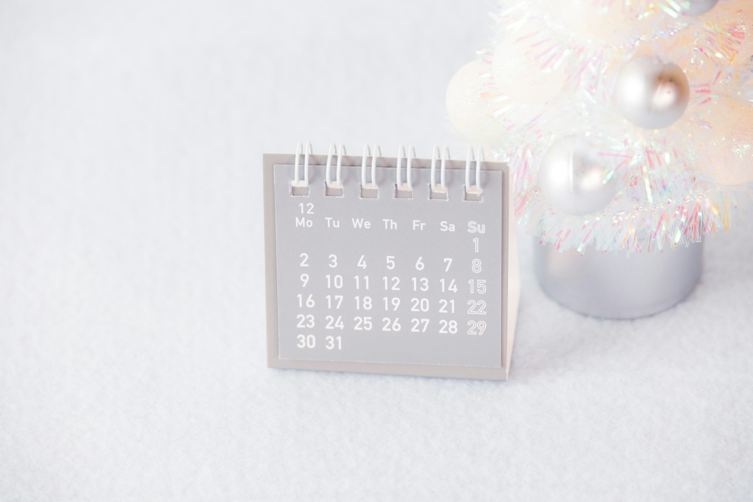 Ein kleiner Kalender neben einem Weihnachtsbaum platziert