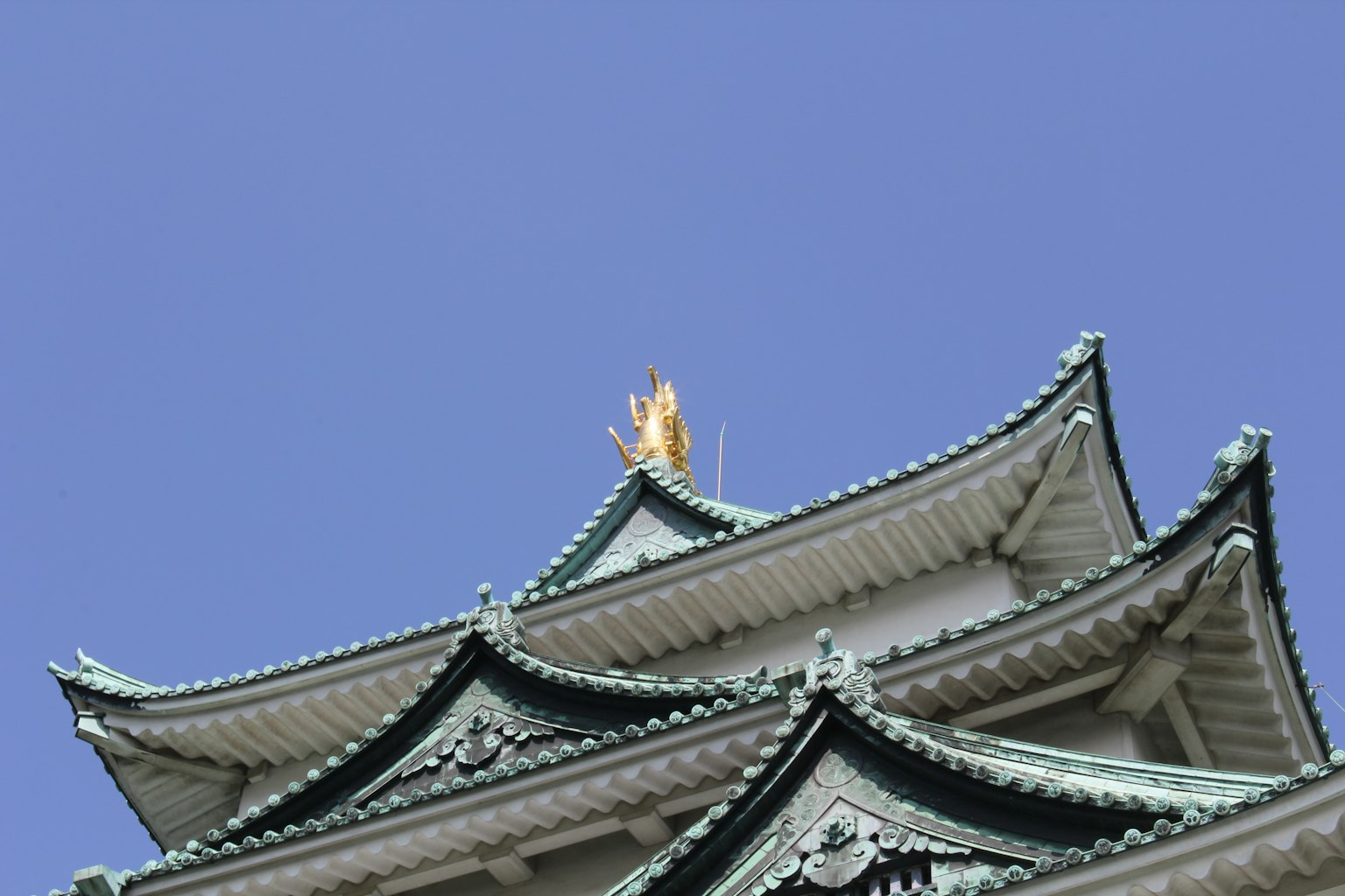 Một phần của mái lâu đài Nagoya trước nền trời xanh