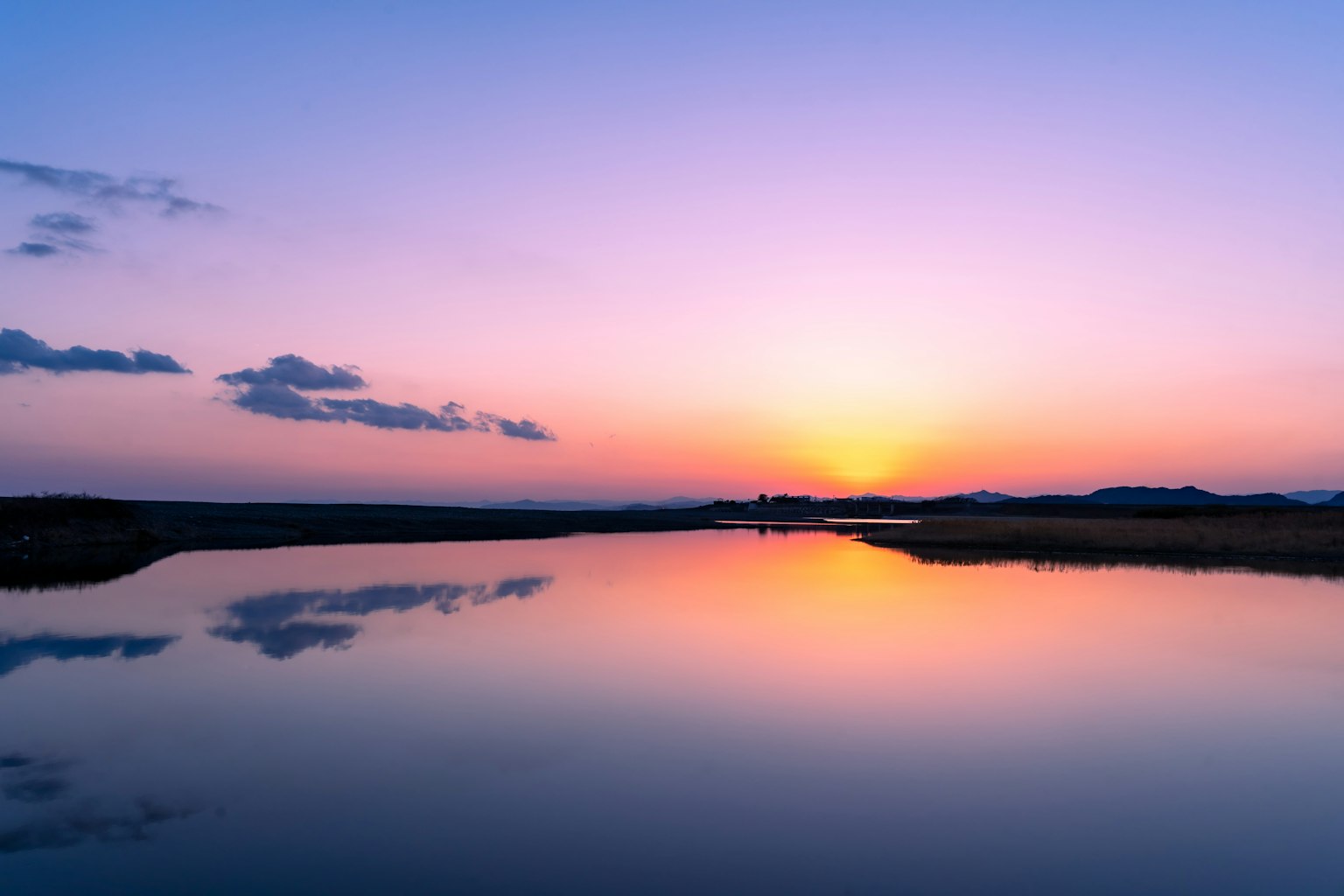 ภาพทิวทัศน์ที่สวยงามของพระอาทิตย์ตกสะท้อนบนผิวน้ำ