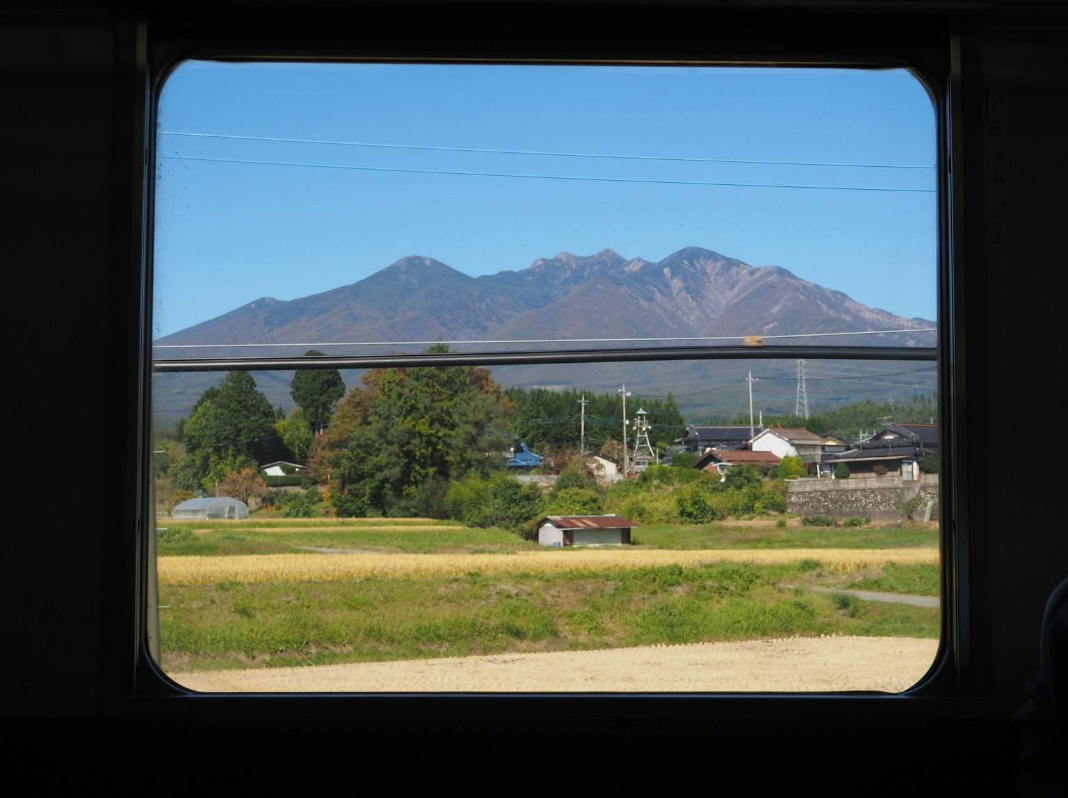 Vista panoramica di montagne e vegetazione attraverso un finestrino del treno