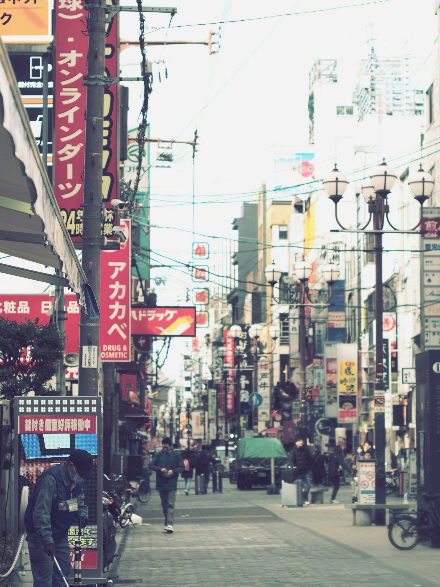 Lebhafte Straßenszene in Japan mit zahlreichen Schildern und Fußgängern