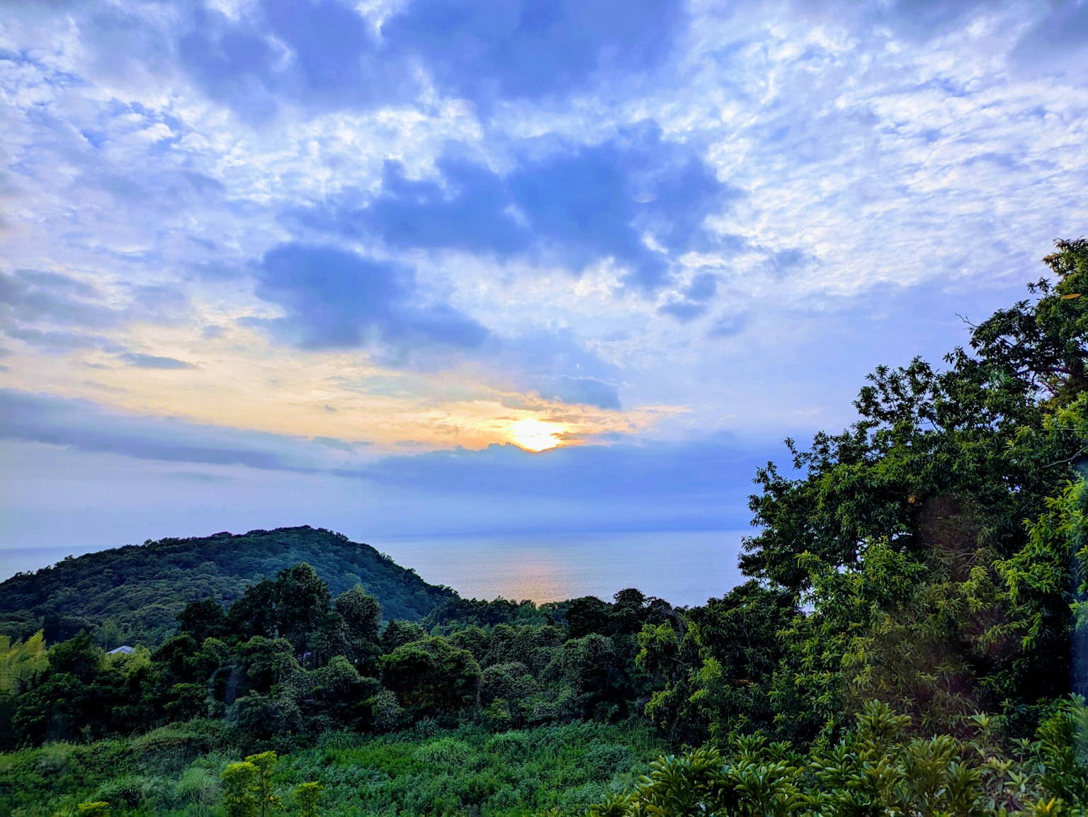 Hermoso cielo de atardecer con colinas y vegetación exuberante