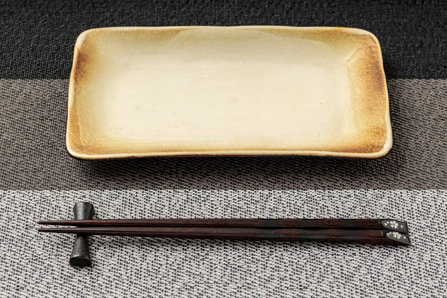 Mise en place simple avec une assiette japonaise rectangulaire et des baguettes laquées