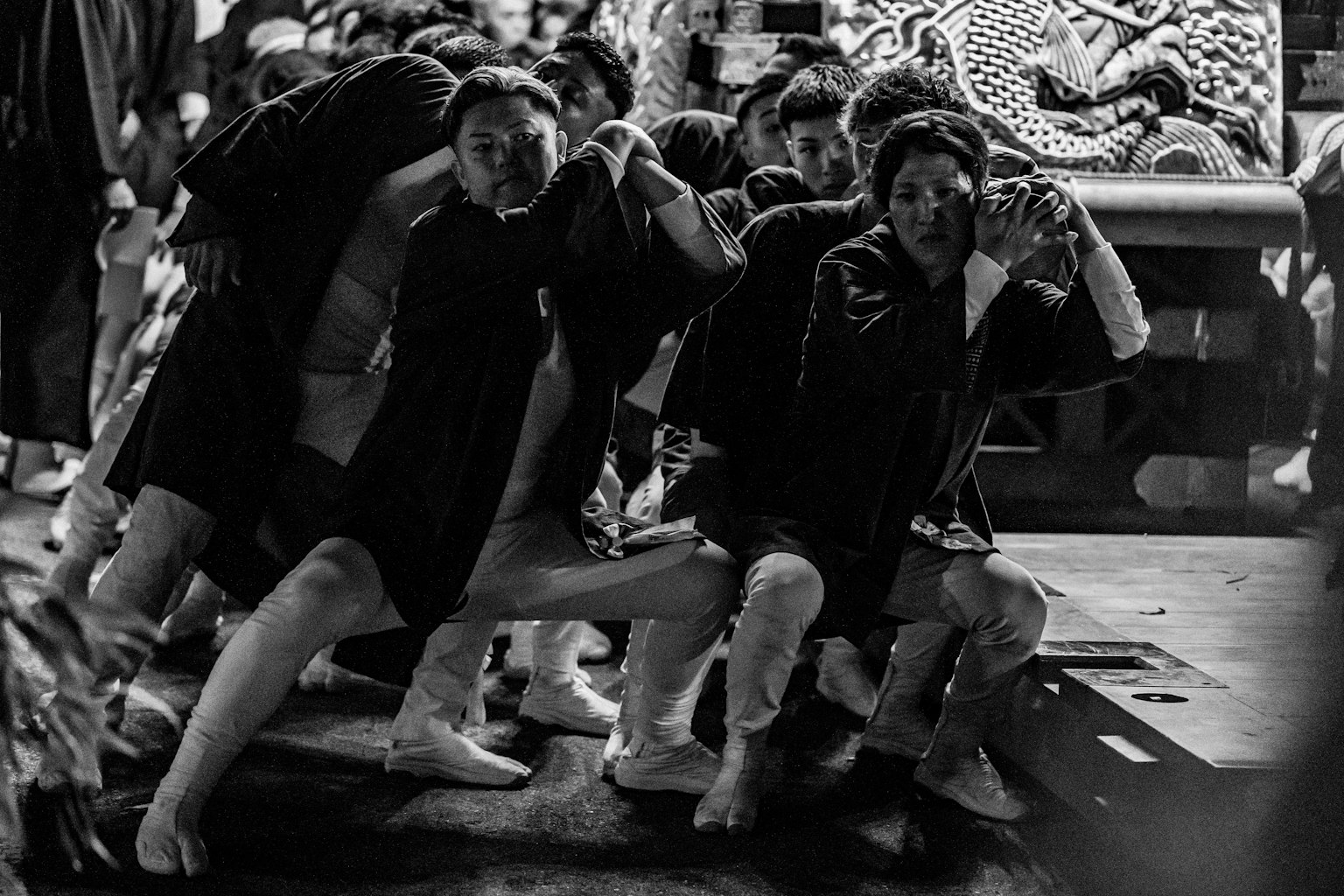 黒白の祭りの中で力強くポーズを取る人々