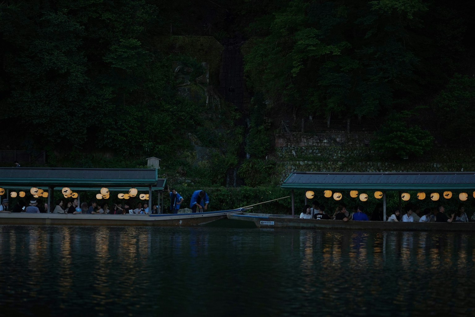 Perahu makan yang diterangi di malam hari di sepanjang sungai
