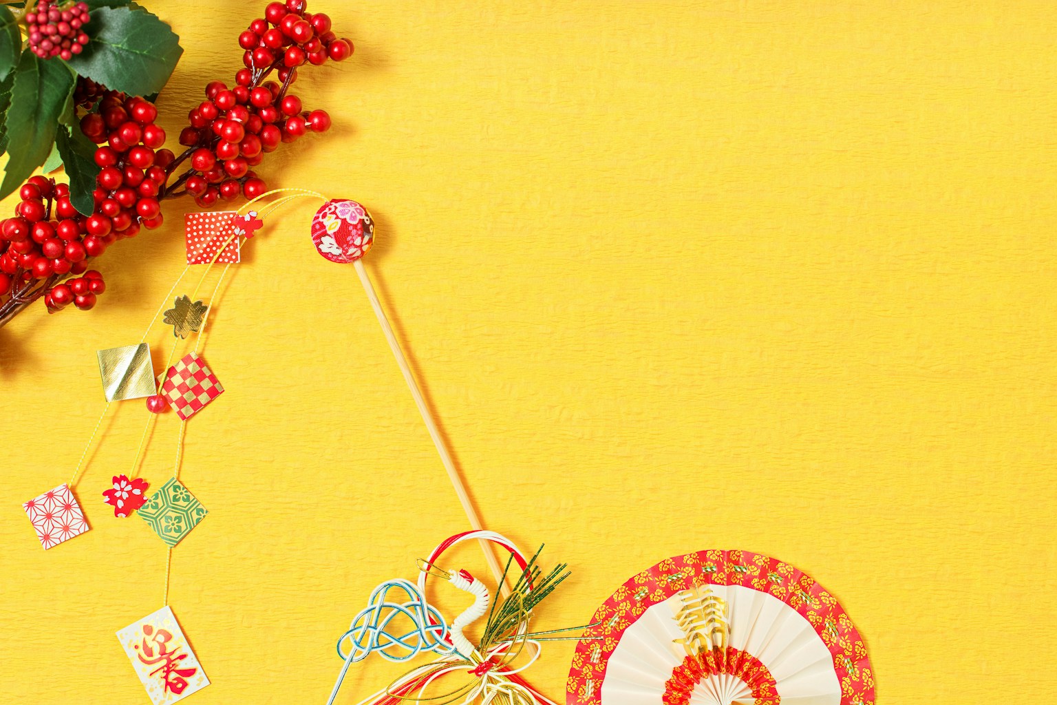 Art composition featuring decorative items and red berries on a yellow background
