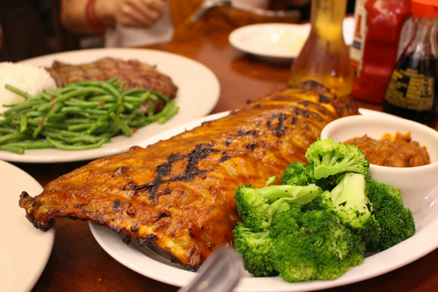 Costine alla griglia con broccoli fagiolini fagioli al forno serviti su un piatto