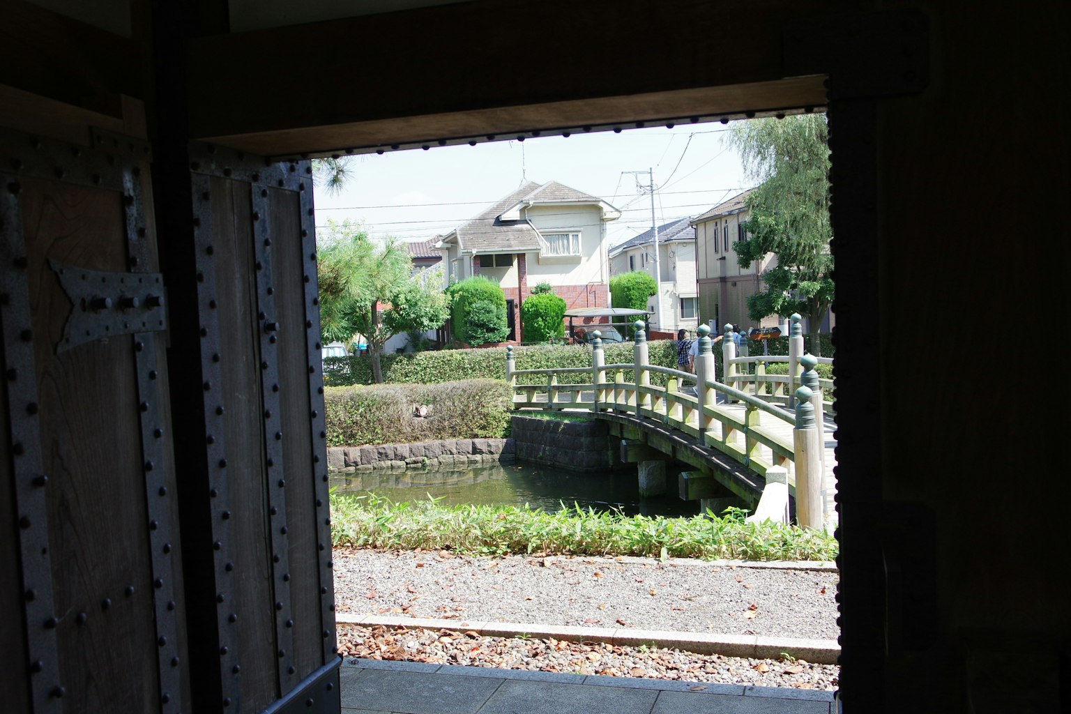 Vista da una finestra con un ponte verde e case in Giappone