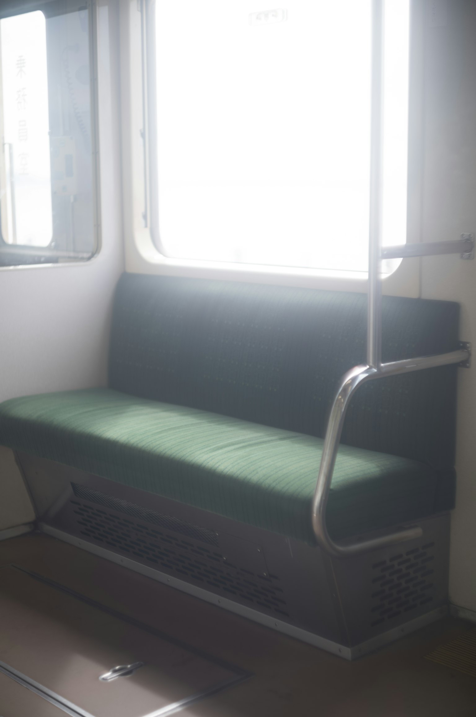 Interior de un tren con un banco verde