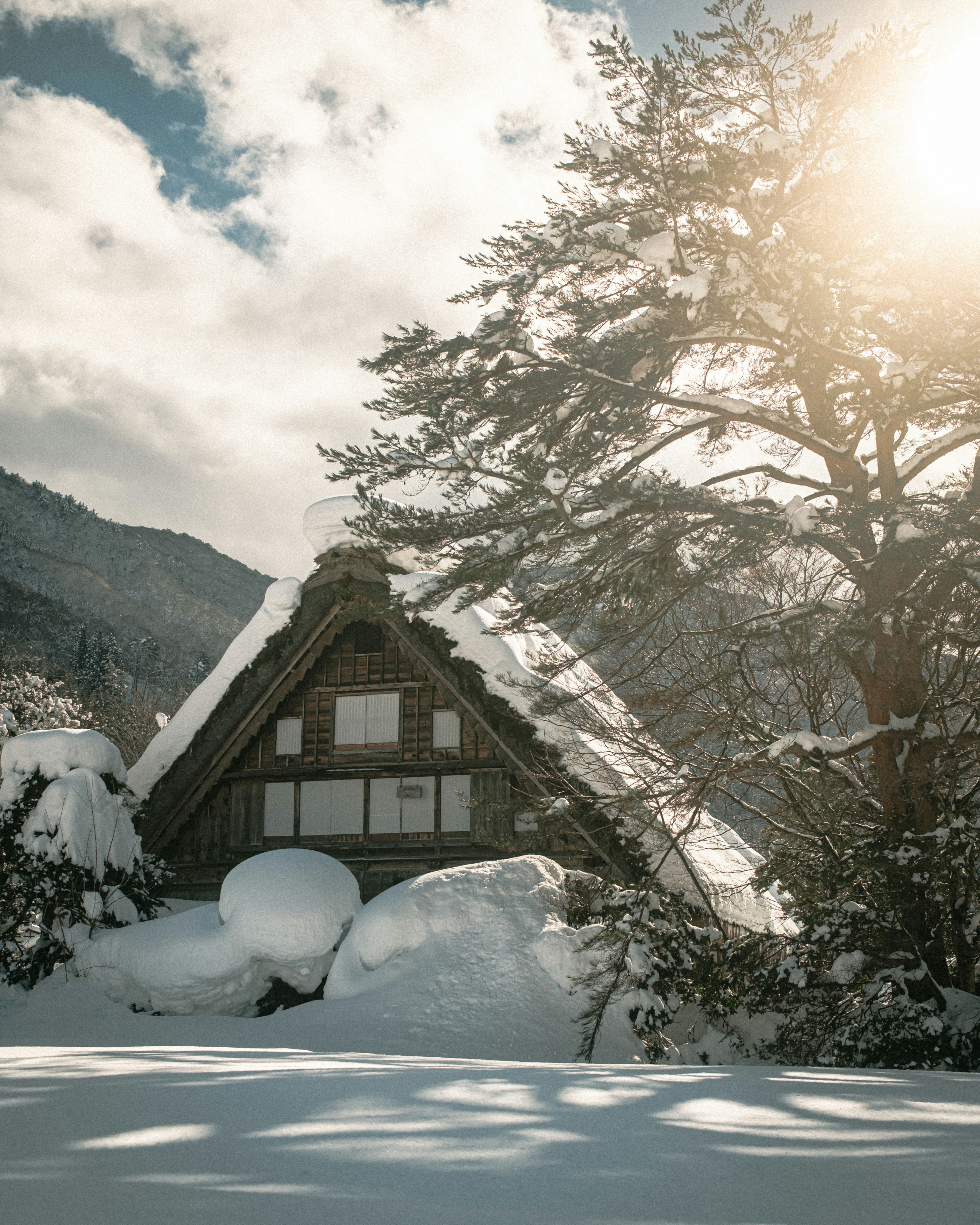 Maison de style gassho couverte de neige et jardin dans une région à fortes chutes de neige