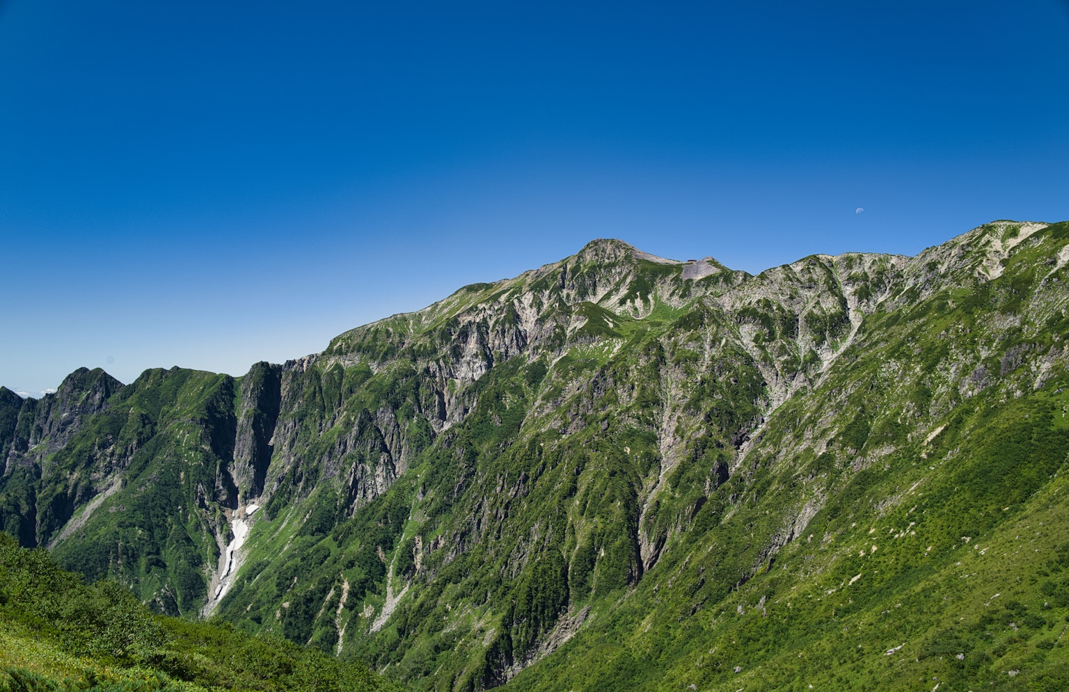 Montagnes verdoyantes sous un ciel bleu clair