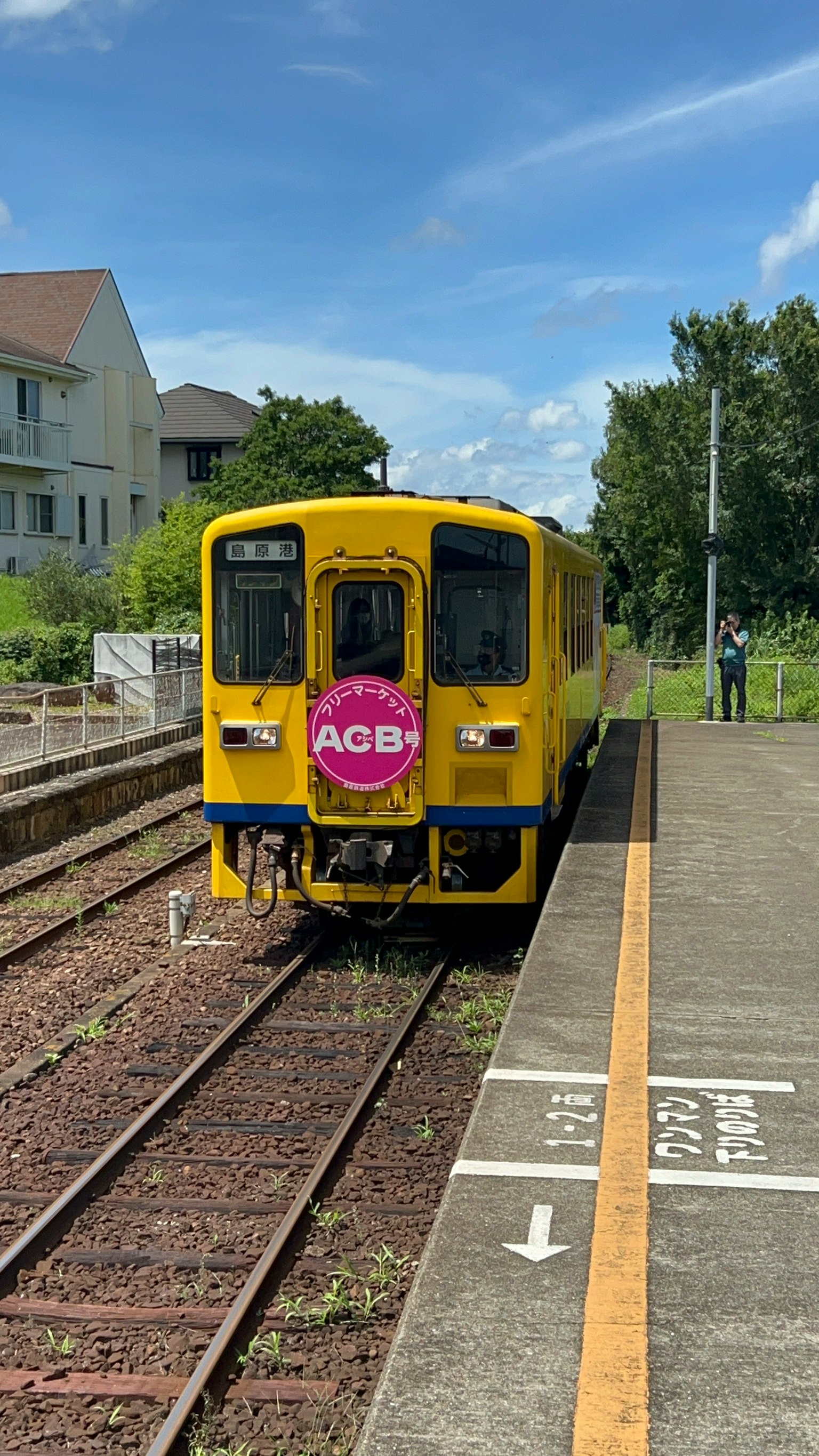 Kereta kuning berhenti di stasiun di bawah langit cerah