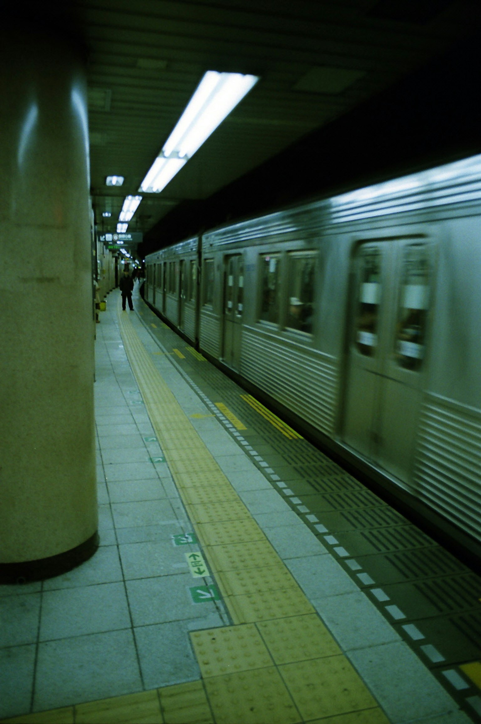 Plateforme de métro avec un train arrivant et des gens attendant