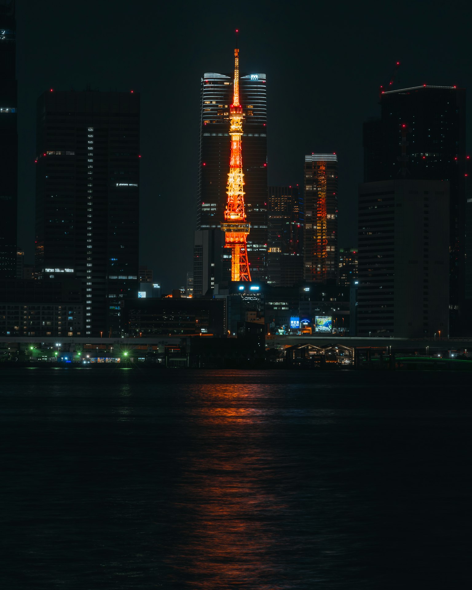 Menara Tokyo yang diterangi di malam hari dengan cakrawala kota