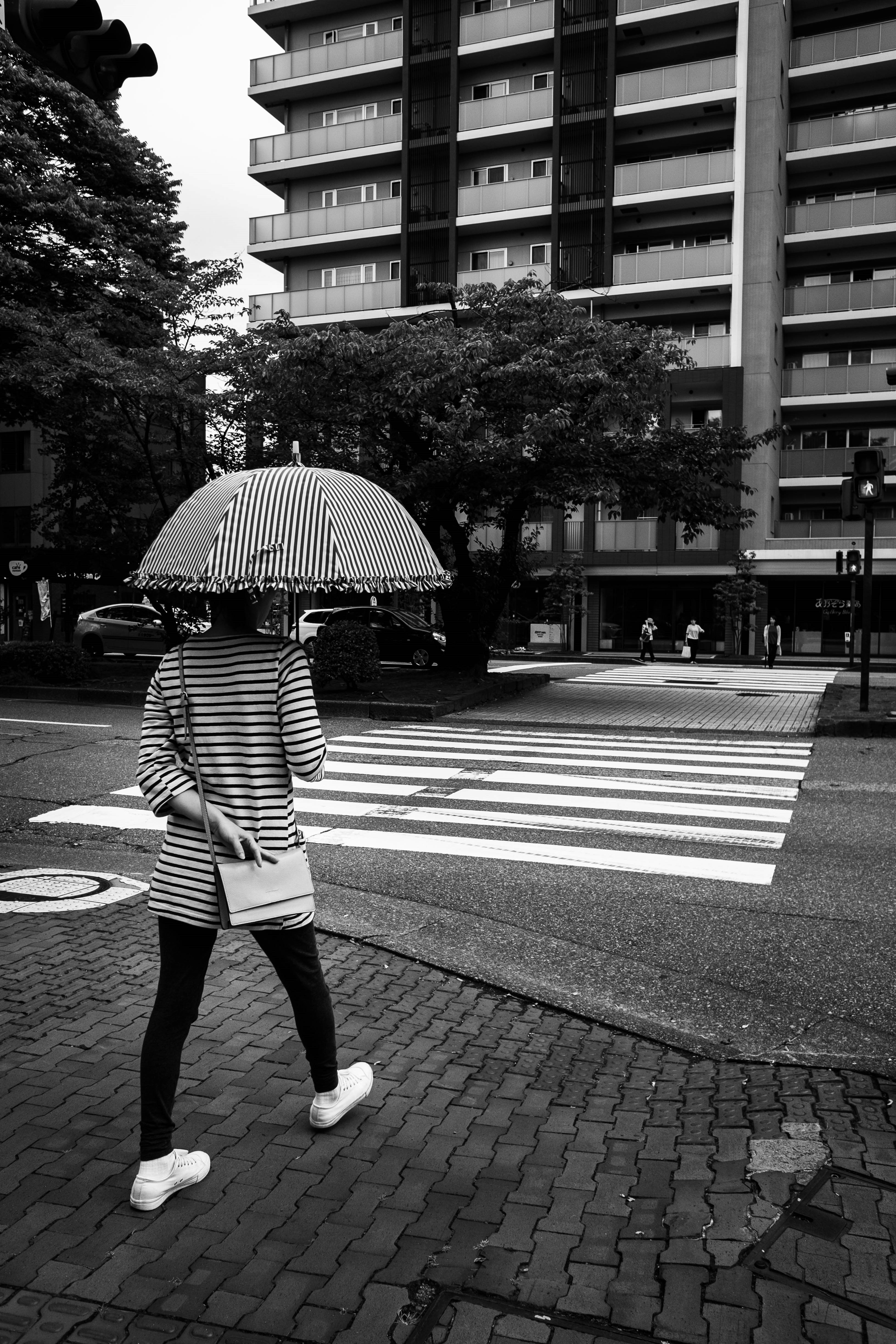 ภาพถนนในเมือง คนกำลังเดินข้ามทางม้าลายหน้าตึก