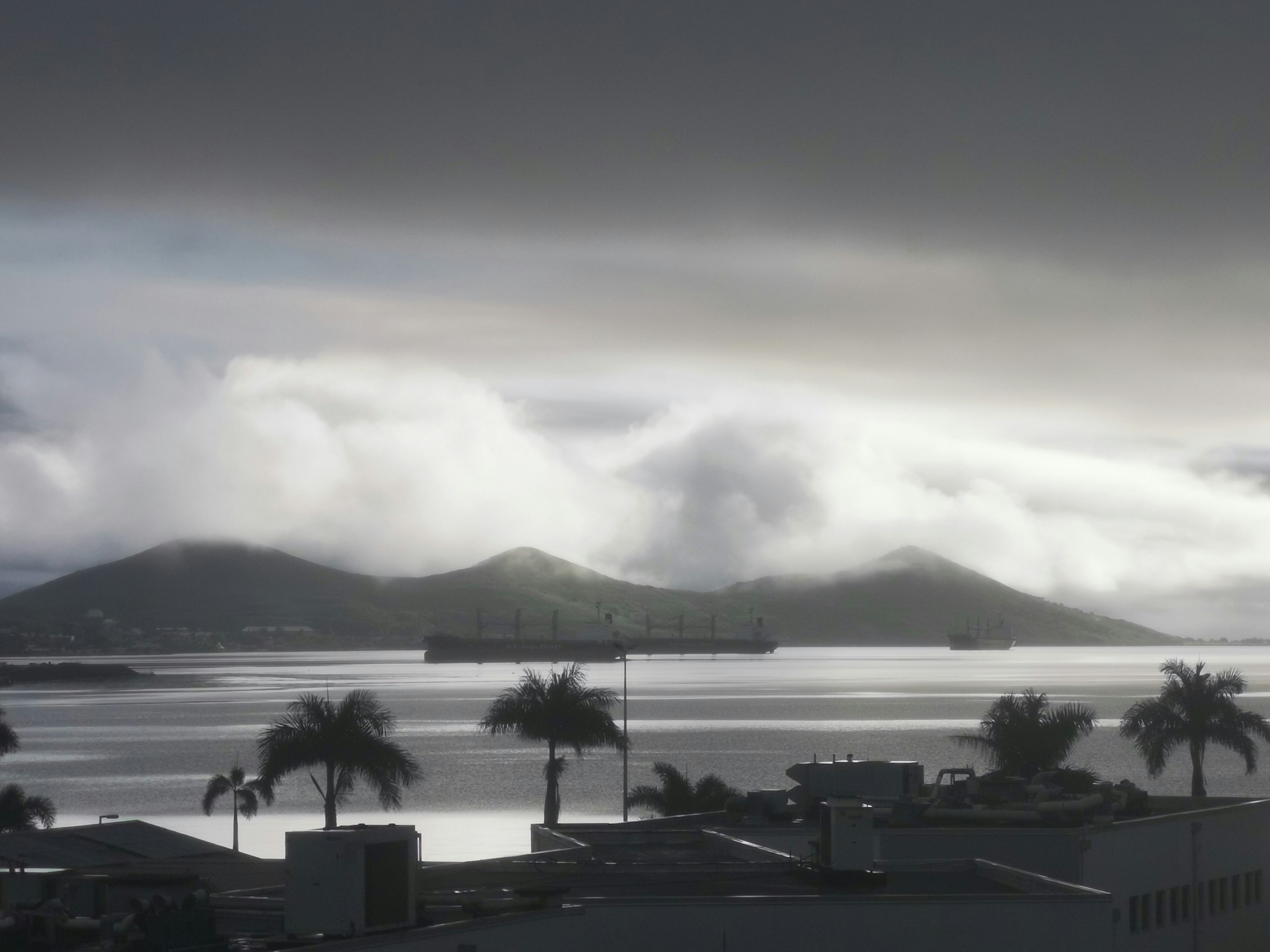 ヌメア湾を望む雲のかかった海岸の景色