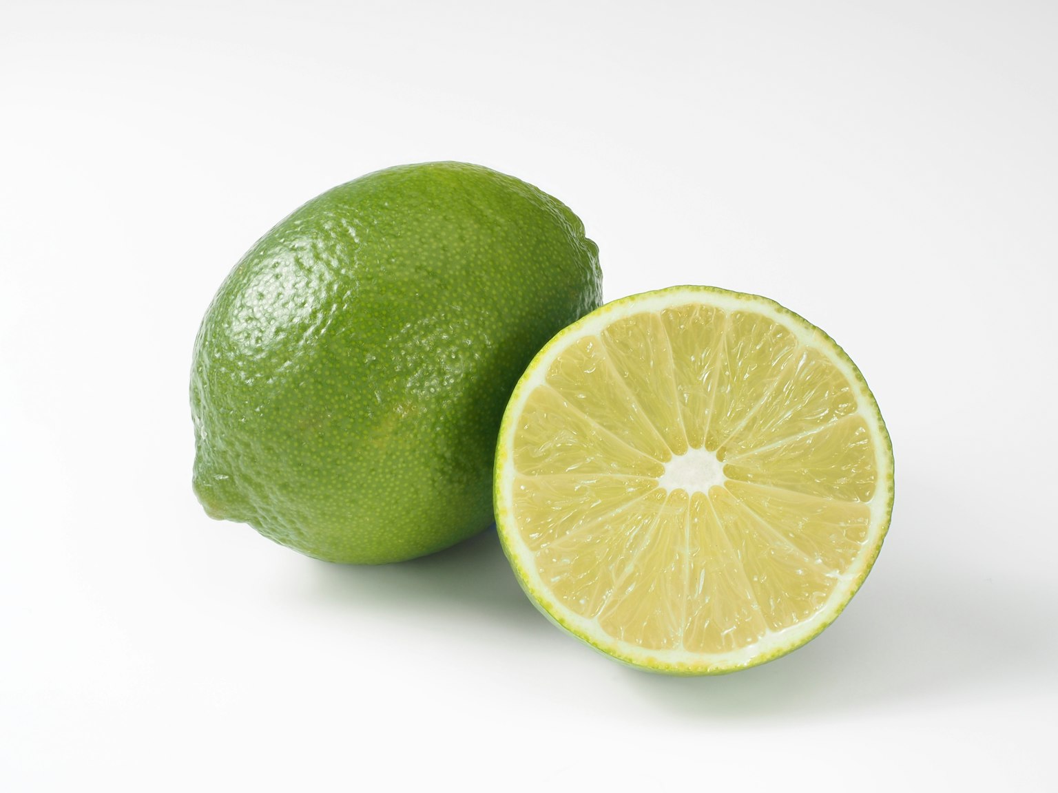 Lime verde e lime tagliato a metà che mostra il suo interno