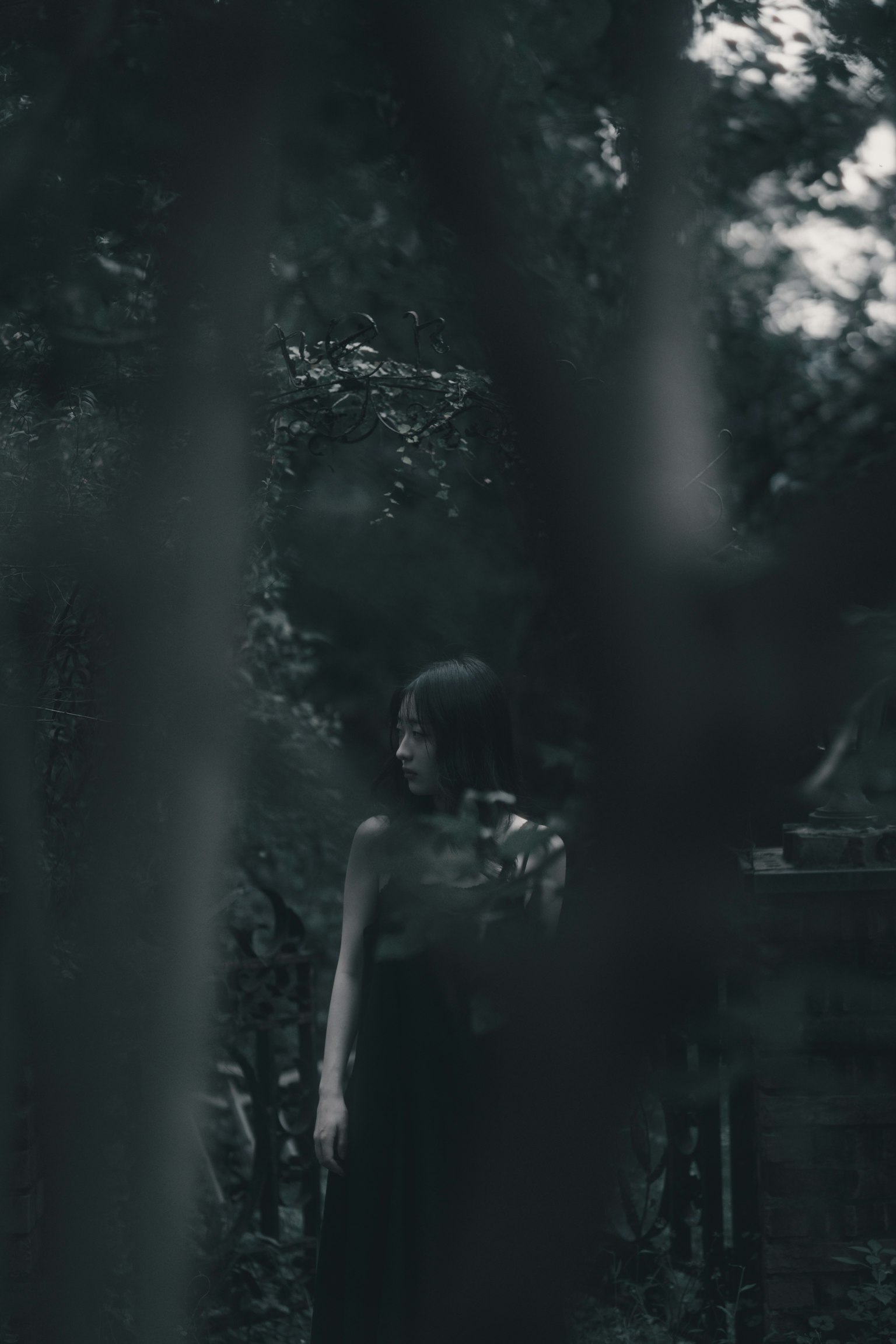 Silhouette einer Frau, die in einem schwach beleuchteten Wald steht