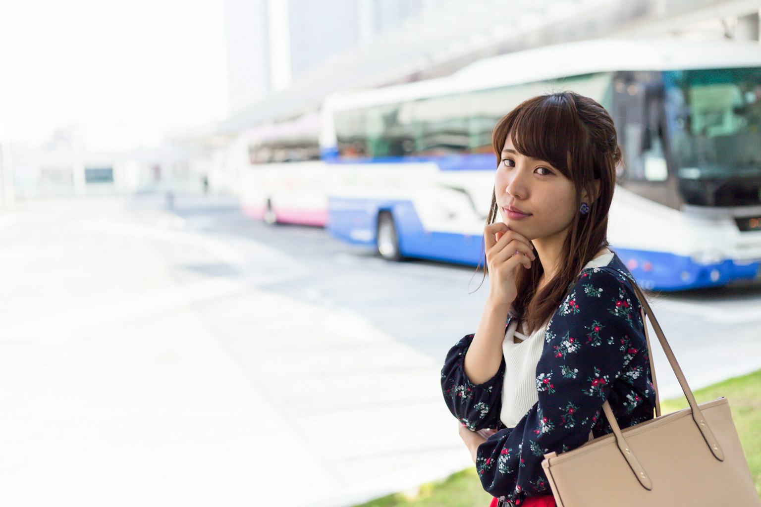 A woman pondering in front of a bus