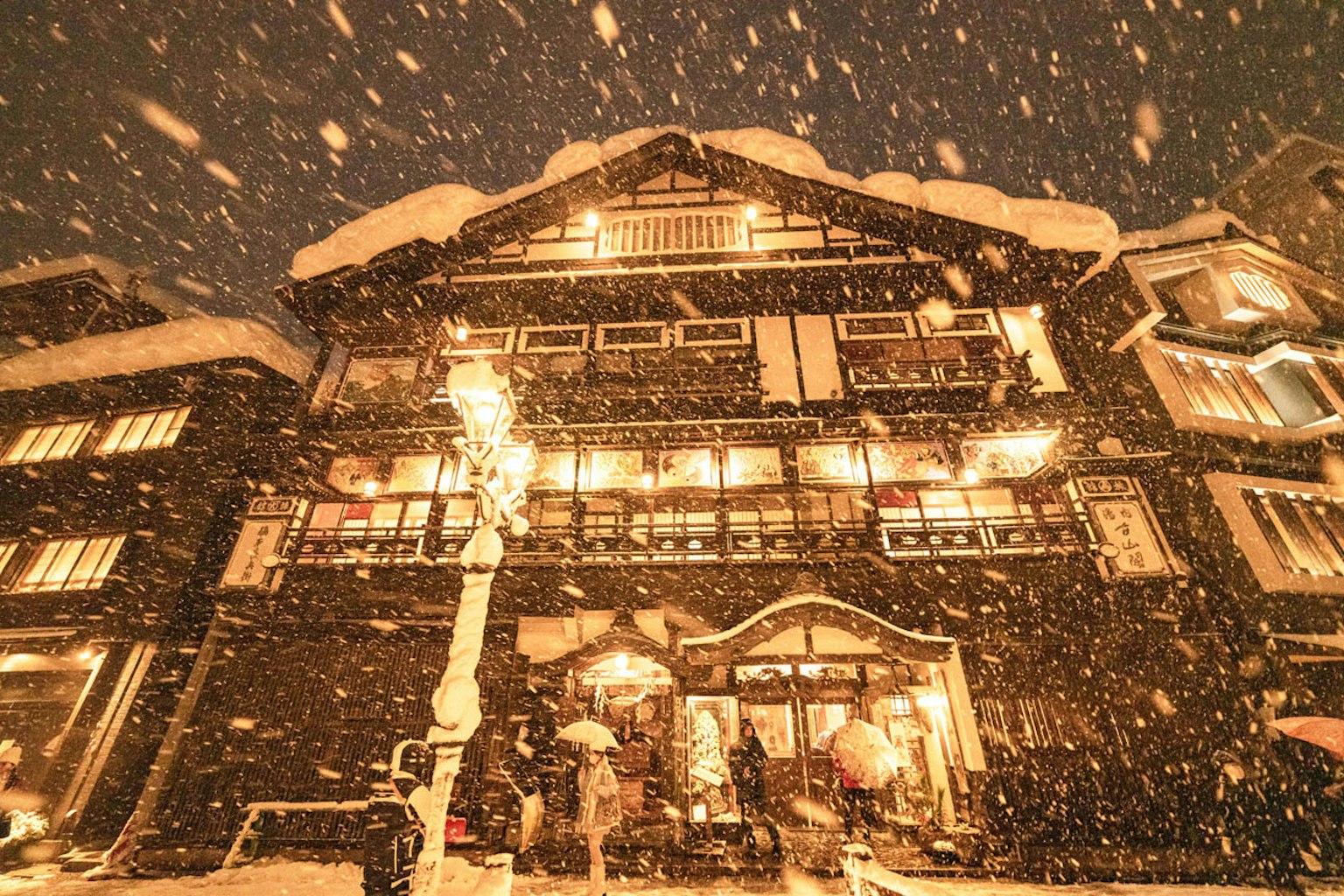 在降雪中被温暖的灯光照亮的传统建筑