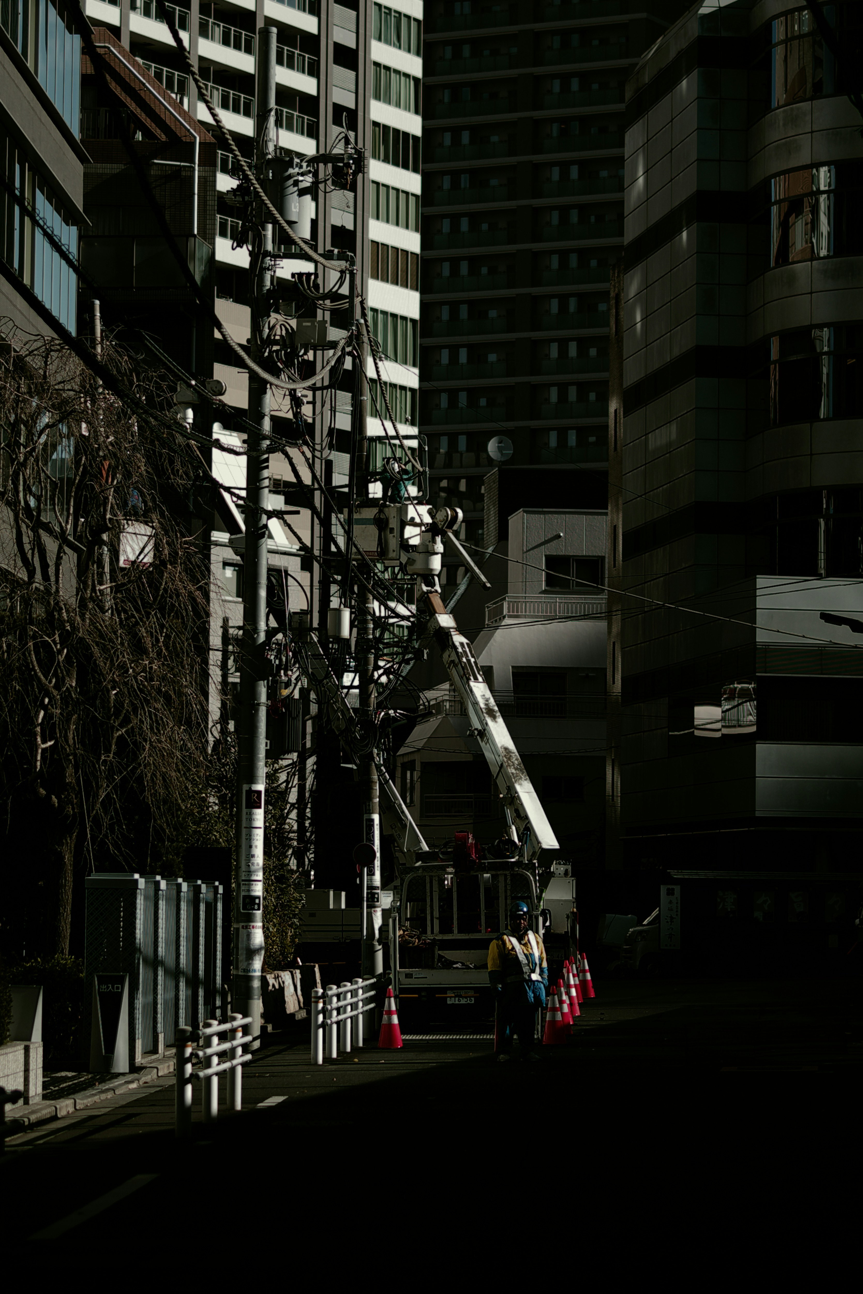 高層ビルに挟まれた電線と配電設備のある街路