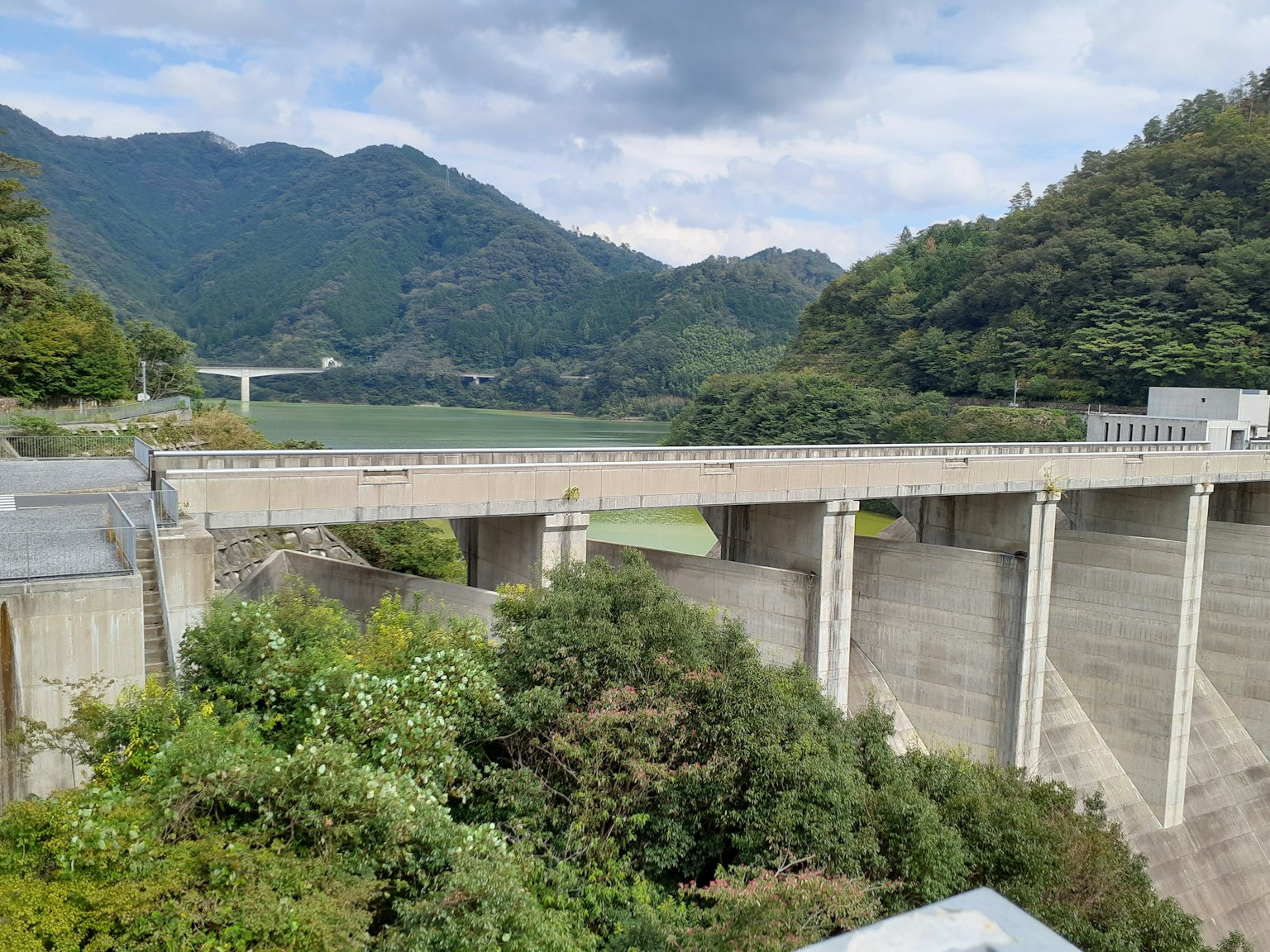 Diga in cemento circondata da montagne e alberi