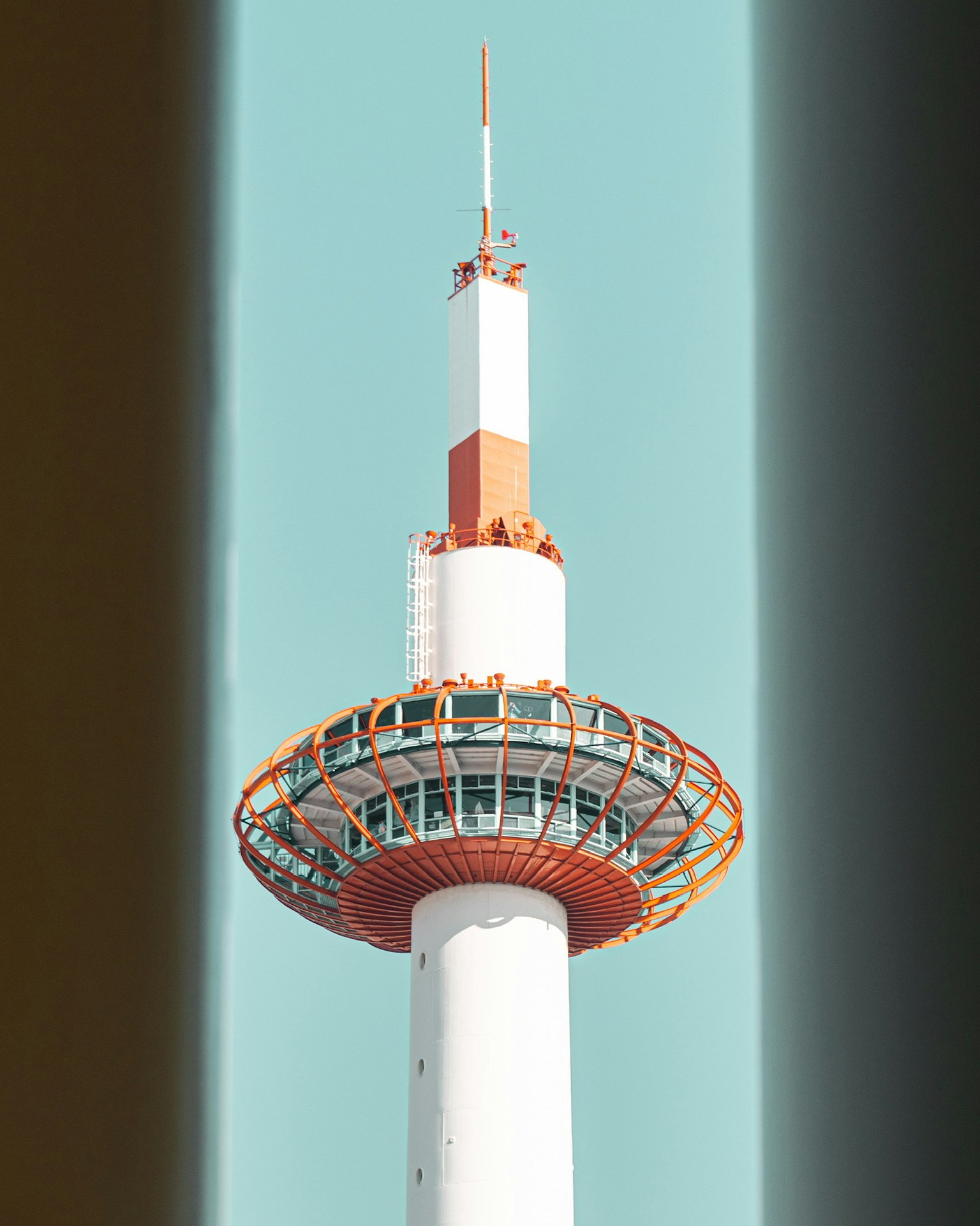 Sommet d'une tour avec une structure circulaire orange contre un ciel bleu