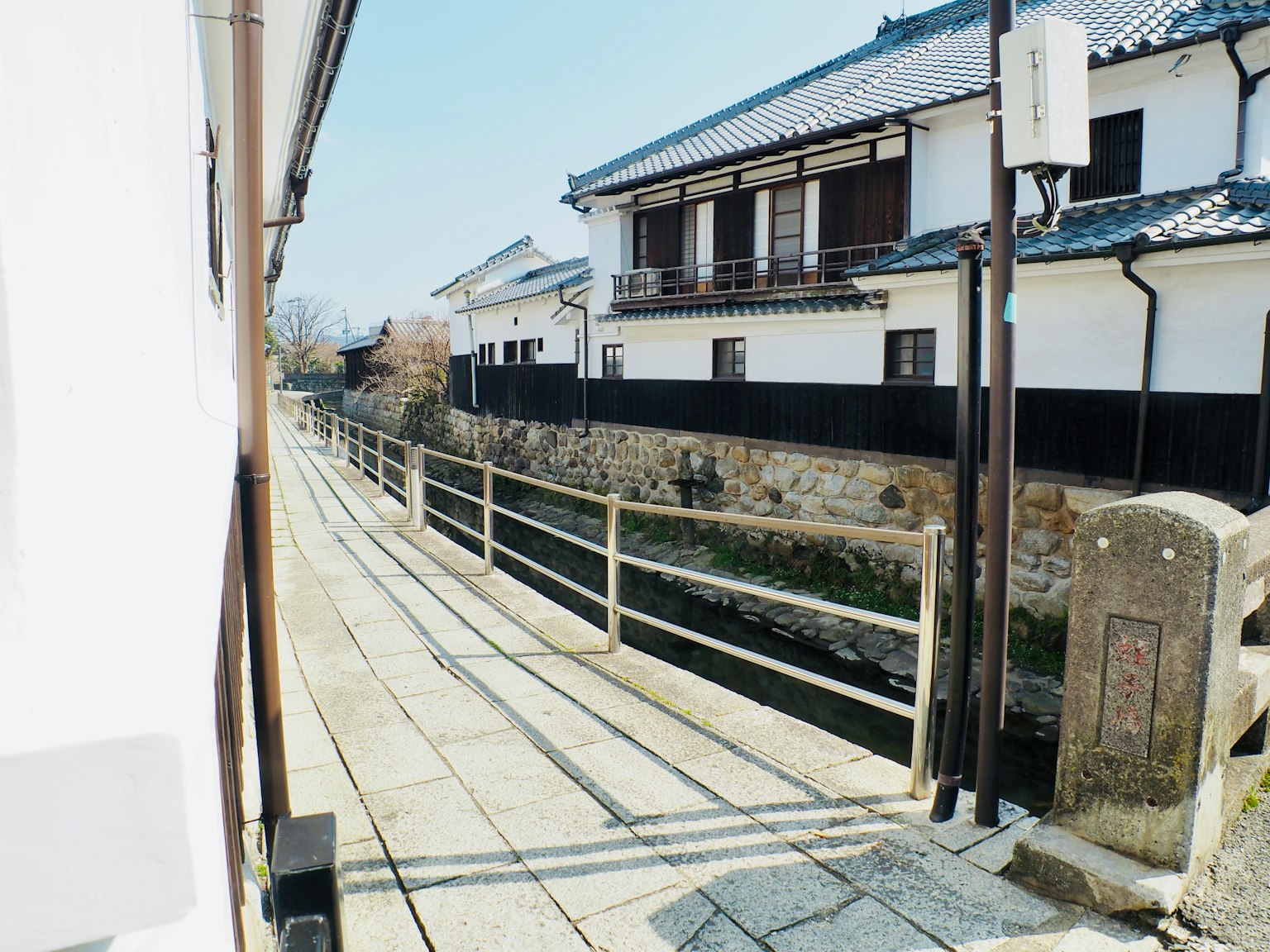 Jalan tenang dengan rumah tradisional Jepang dan tanggul batu