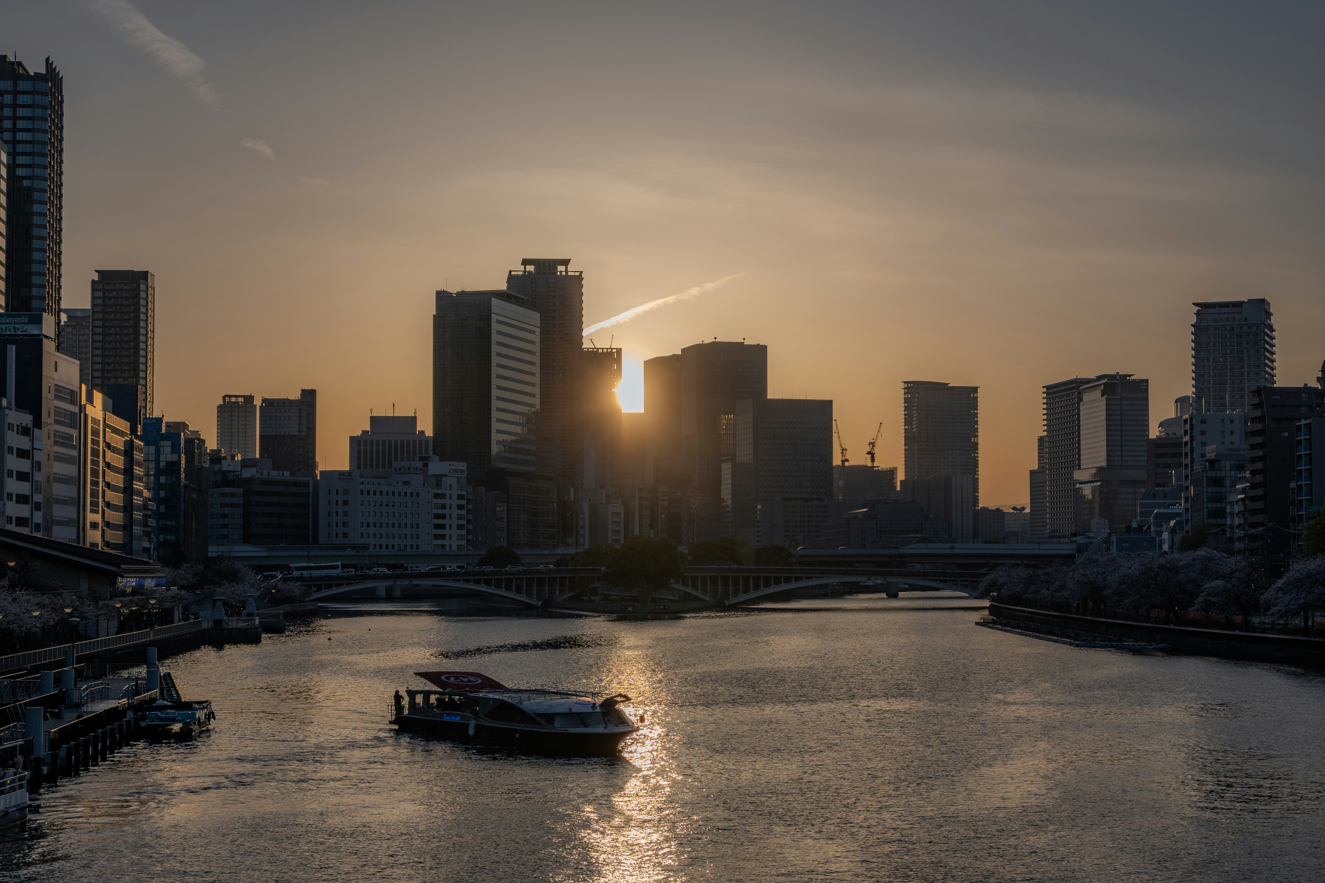 川沿いの都市の夕日と橋のある風景