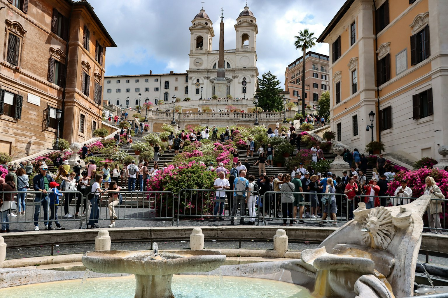 Vista della Scalinata di Spagna con fiori in piena fioritura e folle di persone