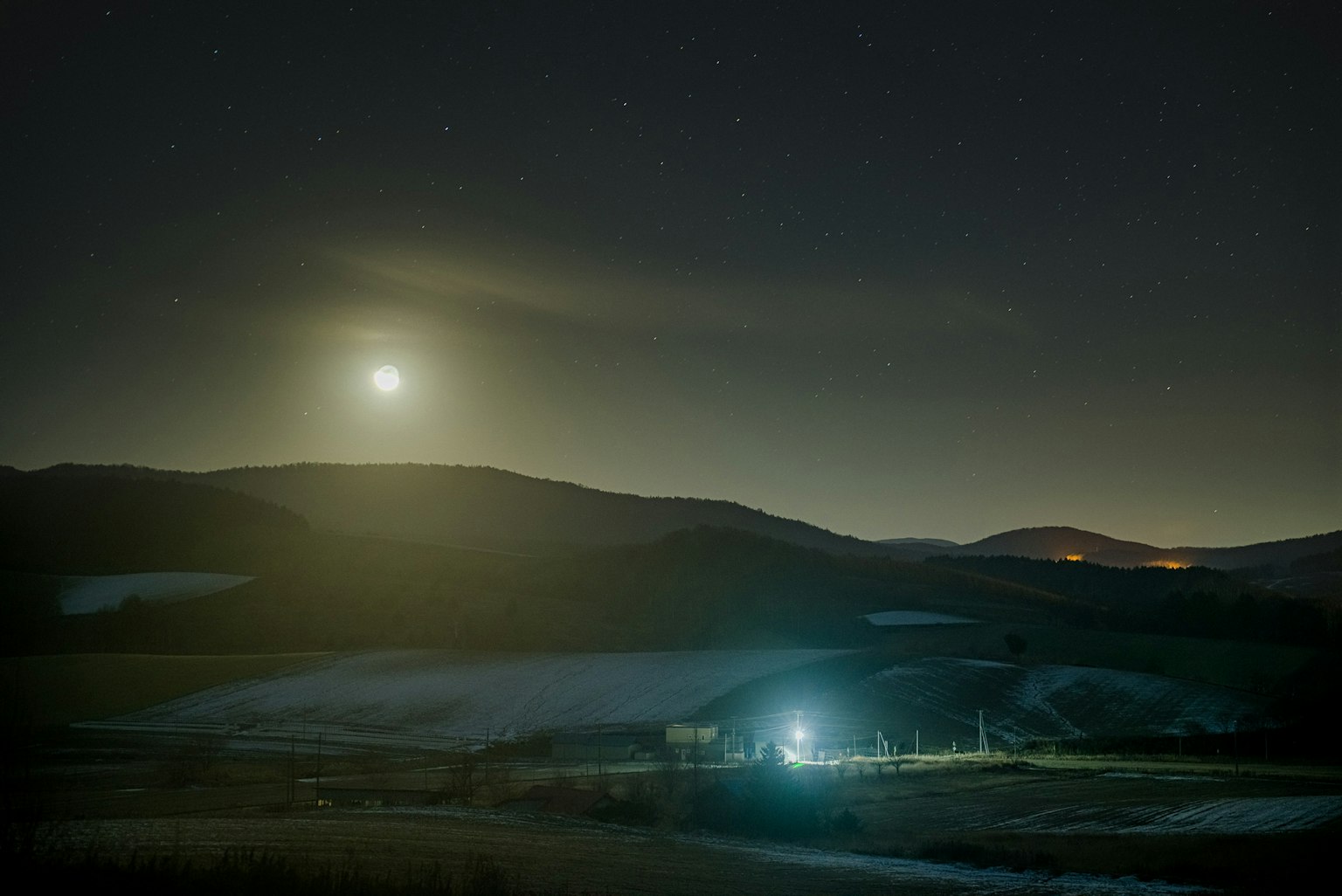 Paesaggio notturno illuminato dalla luce della luna con montagne in lontananza