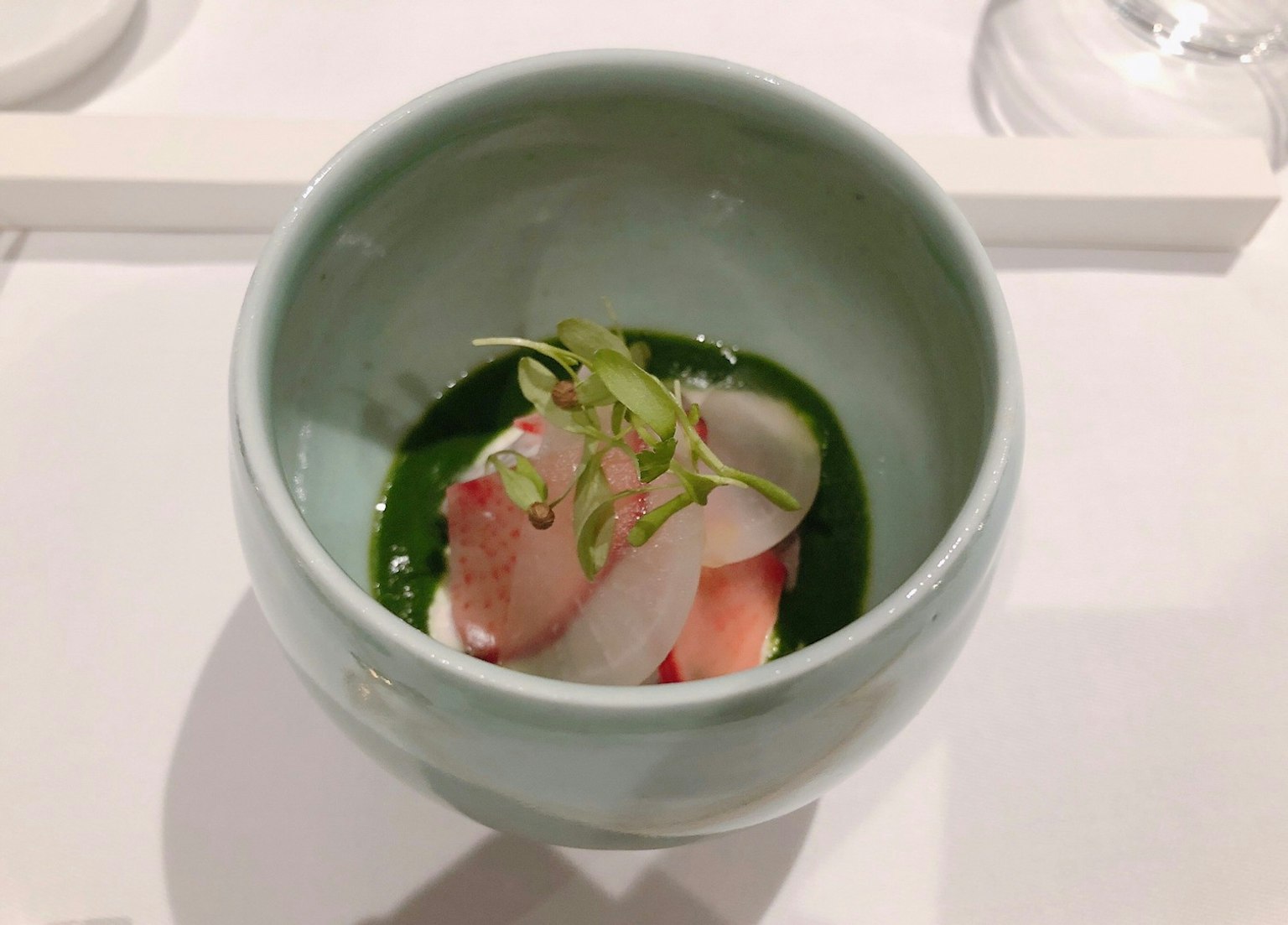 一盤美麗的菜餚，配有綠色醬汁