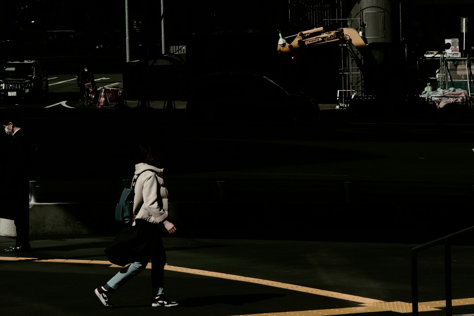 Silhouette di una persona che cammina su uno sfondo scuro con macchinari